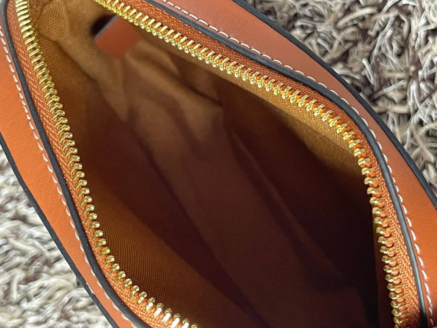 CELINE Triomphe Canvas Small Camera กระเป๋าสะพายไหล่สุดเก๋ใบนี้ผลิตจากผ้าใบเคลือบอย่างดีพร้อมขอบหนังสีน้ำตาล มาพร้อมสายสะพายหนังปรับระดับได้พร้อมฮาร์ดแวร์สีทองและซิปด้านบน ภายในบุด้วยผ้าสีน้ำตาล ลวดลาย triomphe อันเป็นเอกลักษณ์ของแบรนด์ และเป็นกระเป๋าสะพา