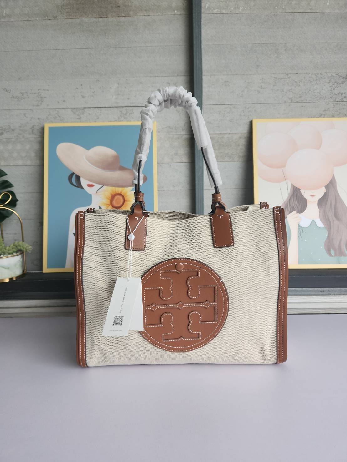 TORY BURCH ELLA CANVAS TOTE BAG กระเป๋าโท้ตน้ำหนักเบาของเราพร้อมป้ายโลโก้ Ella ทำจากผ้าใบที่ทนทานพร้อมรายละเอียดหนังและกระเป๋าด้านใน อเนกประสงค์ ทรงคลาสสิก และสร้างขึ้นอย่างสวยงามด้วยฝีมือช่างฝีมือ สายรัดแคบช่วยให้วางราบกับไหล่ได้อย่างสบาย เหมาะสำหรับทุกว