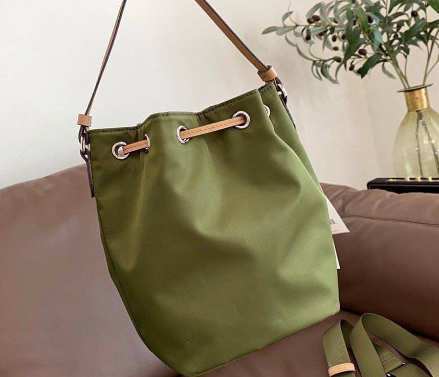 Tory Burch Virginia Nylon Bucket Bag / Tory Burch logo-plaque bucket bag กระเป๋าสะพายทรงบัคเก็ต เปิด-ปิดหนังรูดปากกระเป๋า มีหูหิ้วในตัว คล้องแขนเก๋ๆ ภายในเป็นช่องโล่ง มีช่องย่อย ใส่ของสำคัญจุกจิกได้ มีสายครอส จะสะพายไปไหนก็ได้ทุกโอกาส สวยเลิศทุกสี พร้อมส่