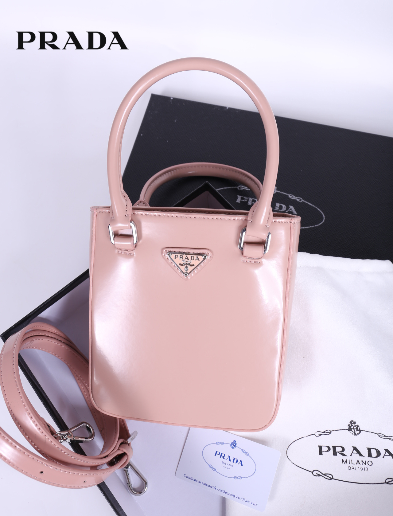 PRADA Small brushed leather tote กระเป๋าTote ขนาดเล็กที่มีดีไซน์ทรงเหลี่ยมโฉบเฉี่ยว วัสดุจากหนังเงาซึ่งเป็นวัสดุที่โดดเด่นของแบรนด์มาตั้งแต่ยุค 90'