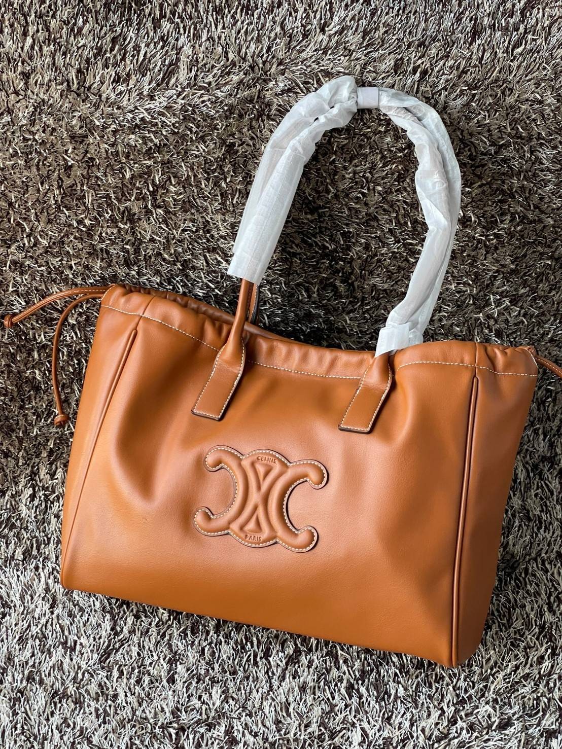 Celine cabas drawstring cuir triomphe in Smooth Calfskin / celine shopping bag เป็นกระเป๋าที่ดีไซน์คลาสสิก เรียบหรู ไม่ตกยุค โดดเด่นเพราะมีโลโก้อยู่ตรงกลาง ออกแบบมาให้ใส่ของใช้ในชีวิตประจำวัน ซึ่งคุณสามารถใช้เป็นกระเป๋าถือหรือสะพายไหล่ก็ล้วนเก๋และมีความคล