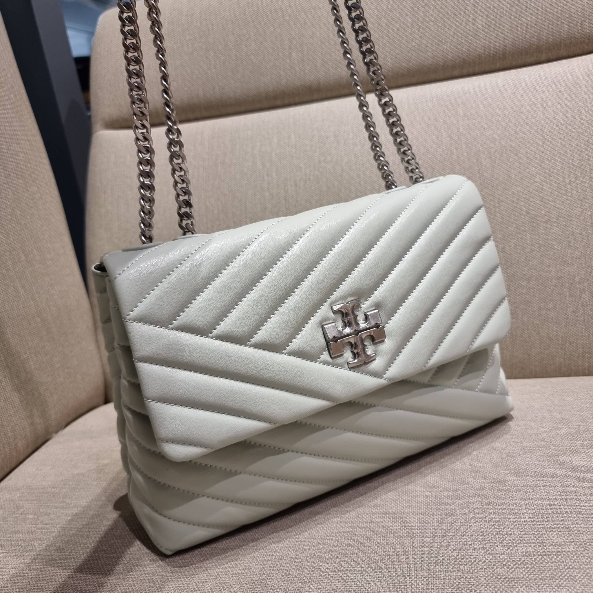 TORY BURCH KIRA CHEVRON CONVERTIBLE SHOULDER BAG กระเป๋าสะพายรุ่นยอดฮิต ไซส์ใหญ่จัดเต็มให้เน้นๆ ใช้ยังไงก็ดูหรู ดีไซน์เฉพาะตัว วัสดุหนังแกะ สัมผัสนิ่ม เปิด-ปิดด้วยกระดุมแม่เหล็ก ภายในเป็นช่องโล่ง แบ่งสัดส่วนไว้ดีมากๆ ใส่กระเป๋าสตางค์ มือถือ เครื่องสำอางค์