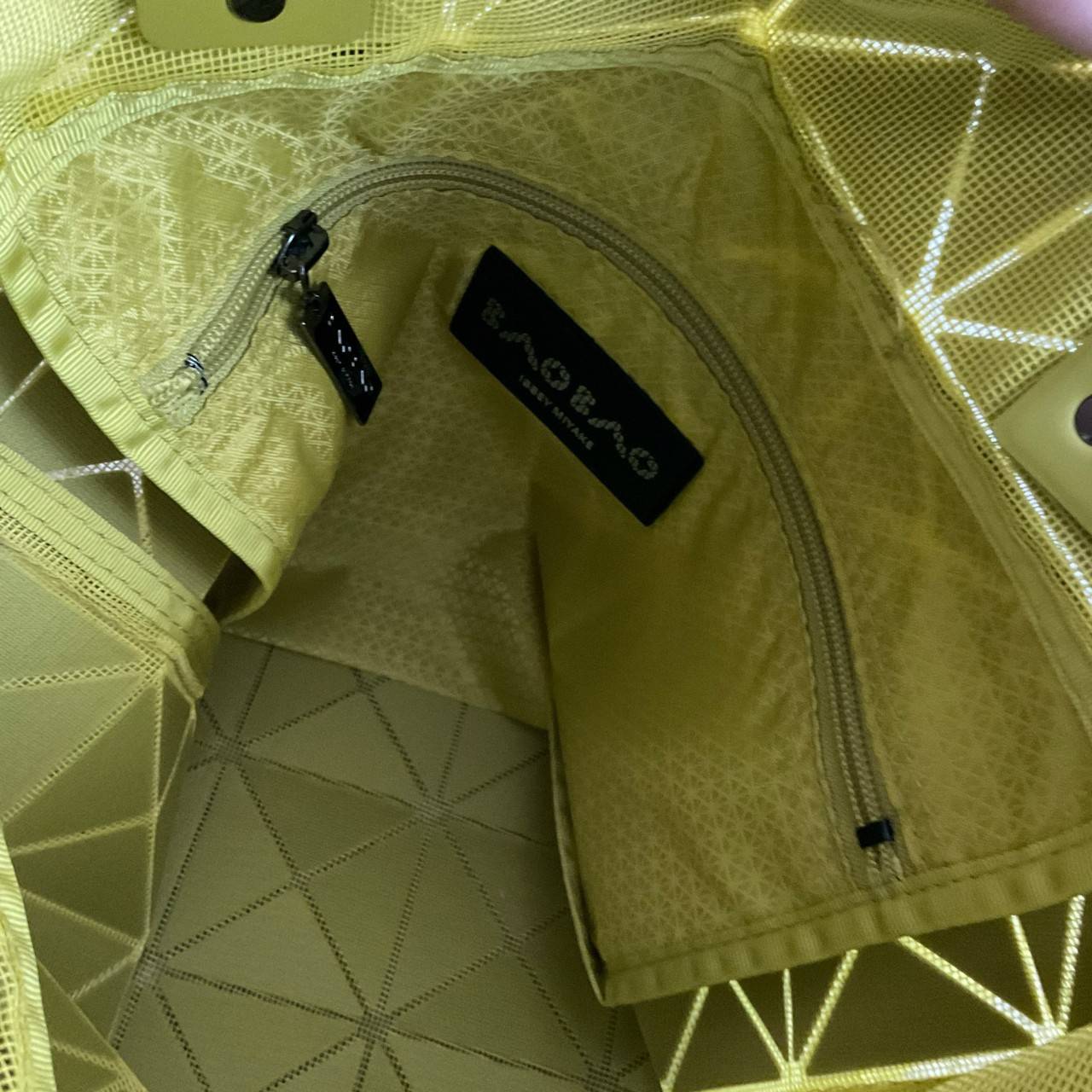 BAO BAO ISSEY MIYAKE LUCENT ONE-TONE กระเป๋าสะพายไหล่ ทรงโท้ท ใบใหญ่สวยมาก ปรับได้หลายทรงตามเอกลักษณ์เฉพาะของแบรนด์นี้ วัสดุ 100% POLYESTER PARTLY: SYMYHETIC LEATHER ด้านในใส่ของได้เยอะมาก ใส่ไอแพด สมุดโน้ตได้สบายเลย วัยทำงานหรือวัยนักศึกษา อย่างน้อยต้องม