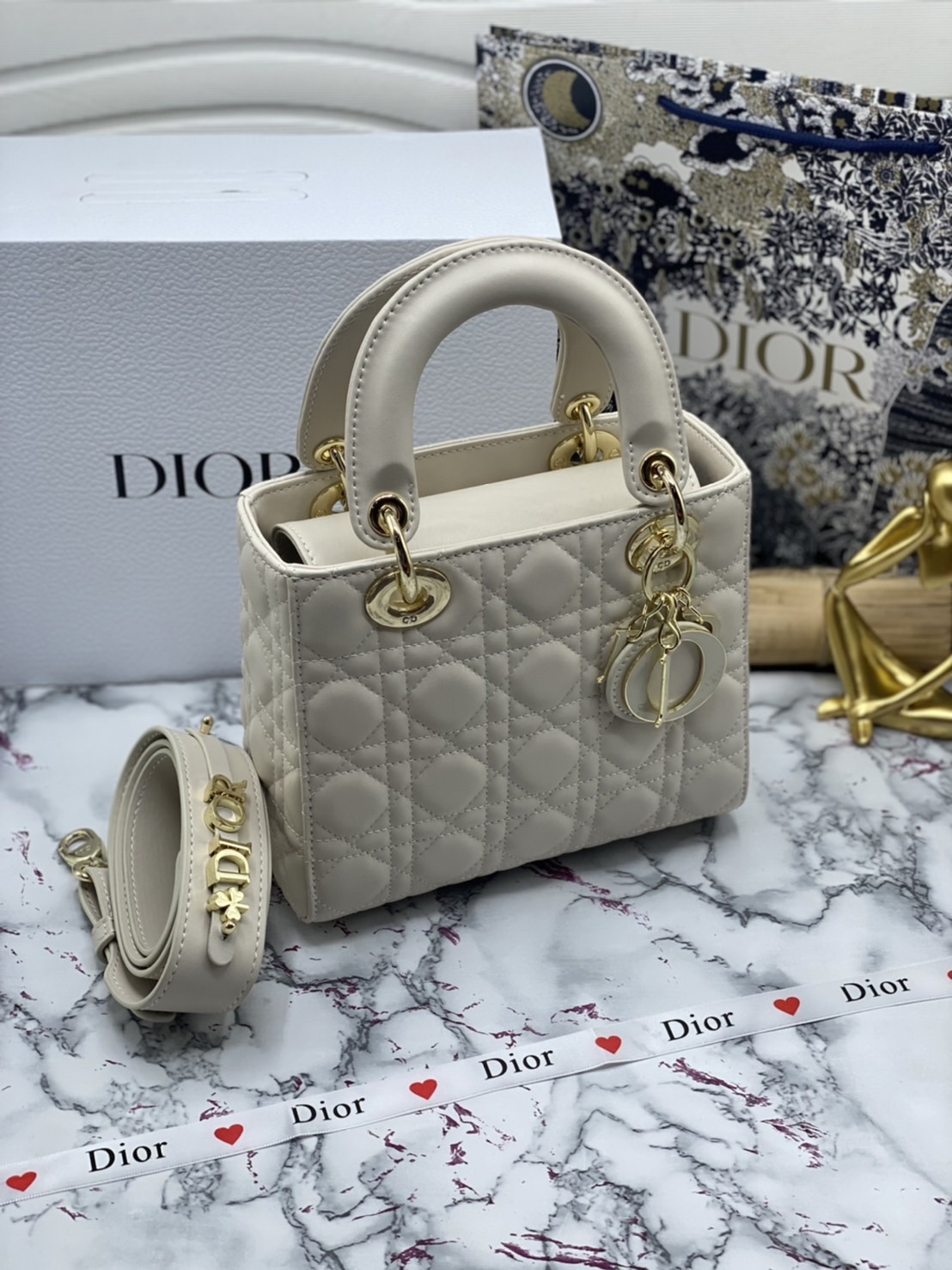 หนังแท้ DIOR LADY BAG 20cm ความสง่างามอีกหนึ่งรุ่นของ Dior รูปทรงสีเหลียม ขนาดกระทัดรัด ตั้งอยู่ทรง ฐานกระเป๋าแข็งแรง มีหมุดรองฐาน ดีไซน์ที่มีเอกลักษณ์เฉพาะตัว ด้านหน้าตกแต่งด้วยตัวอักษร D.I.R ห้อยเป็นพวงกุญแจ จะถือด้วยมือหรือสะพายไหล่ก็ดูดีมากๆ ค่ะ