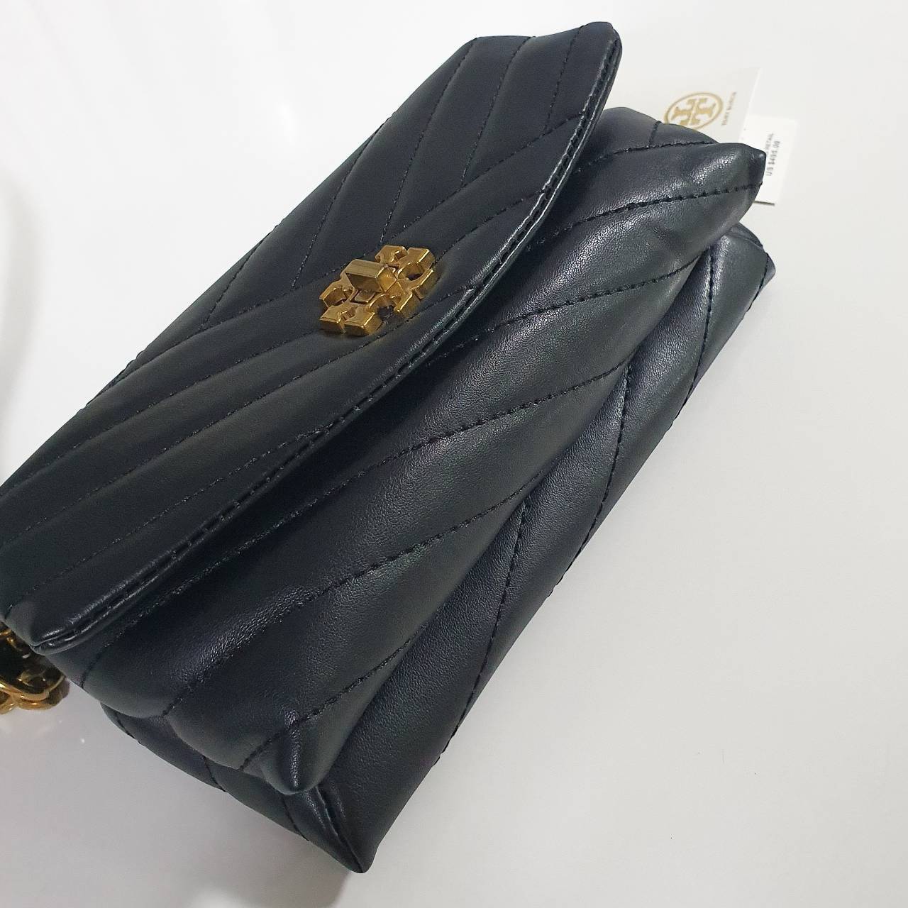 Tory Burch Kira Crossbody Bag กระเป๋าสะพายข้างทรงสวย ใบขนาดเล็กกำลังดี วัสดุหนังสังเคราะห์ นิ่มมือมากกก **อะไหล่ทองวินเทจ ประดับโลโก้แบรนด์เป็นตัวล็อคด้านหน้า ด้านในบุผ้าไนลอนปั้มแบรนด์ แบ่งช่องเป็นสัดส่วน พร้อมช่องซิปกลาง สามารถใส่กระเป๋าสตางค์ใบกลาง มือ