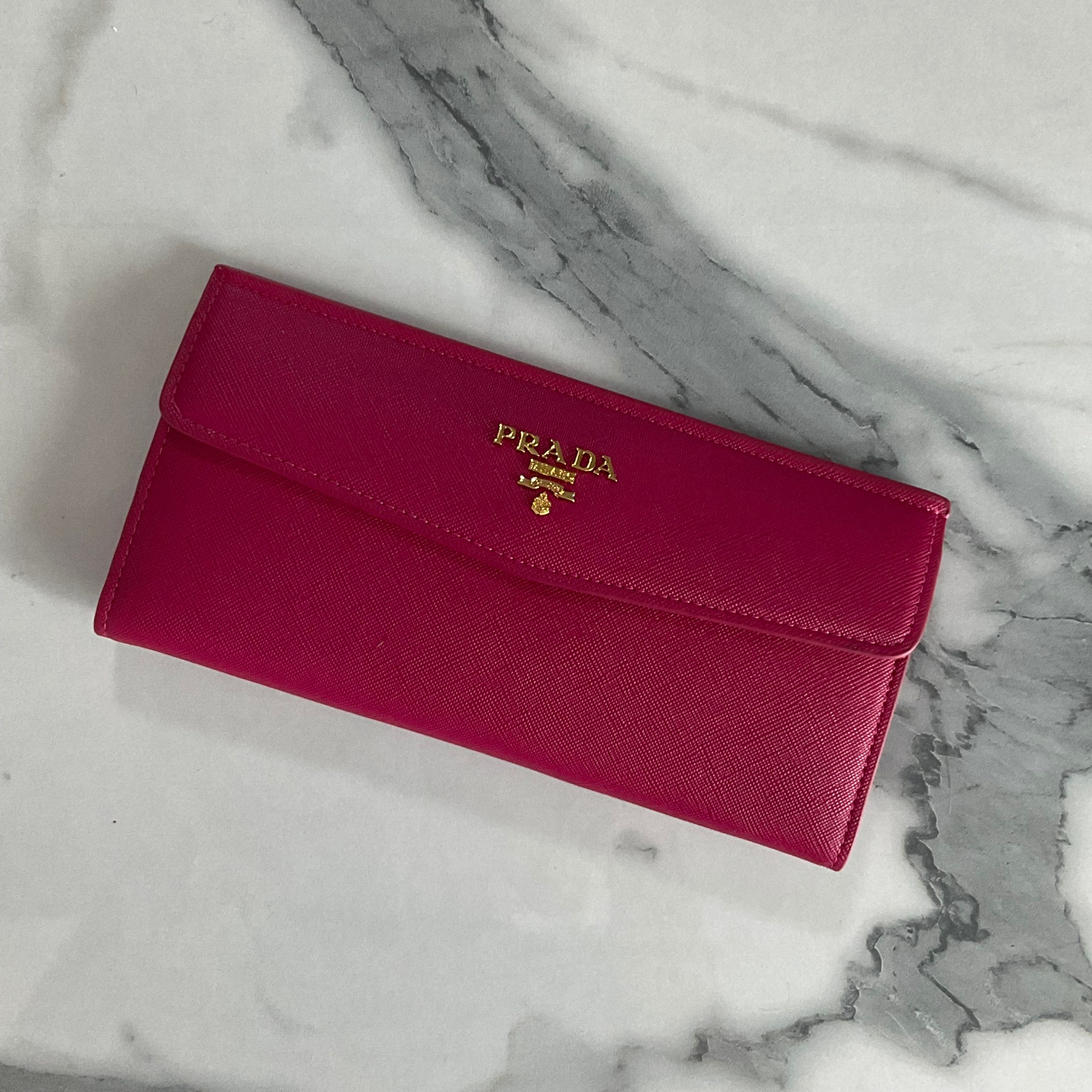 PRADA LONG WALLET Best Seller กระเป๋าสตางค์รับทรัพย์ ทรงหรู ลายหนัง SAFFIANO มีช่องใส่บัตร ถึง 12 ช่อง และช่องซิปใส่ของจุกจิกได้ น้ำหนักเบา จับถนัดมือ ขนาดกำลังดี