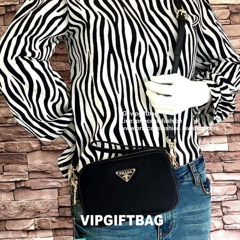 PRADA CROSSBODY BAG WITH ZIP GIFT WITH PURCHASE (GWP) กระเป๋าสะพายพรีเมี่ยมกิ้ฟ Limited Edition จากเคาน์เตอร์แบรนด์ดีไซน์เรียบหรูดูดี วัสดุ Nylon & Polyester 100% เนื้อหนาคุณภาพดีตามแบบฉบับของแบรนด์ ด้านหน้าประดับโลโก้มีช่องแบ่ง2 ช่องเป็นสัดส่วนเปิดปิดด้ว