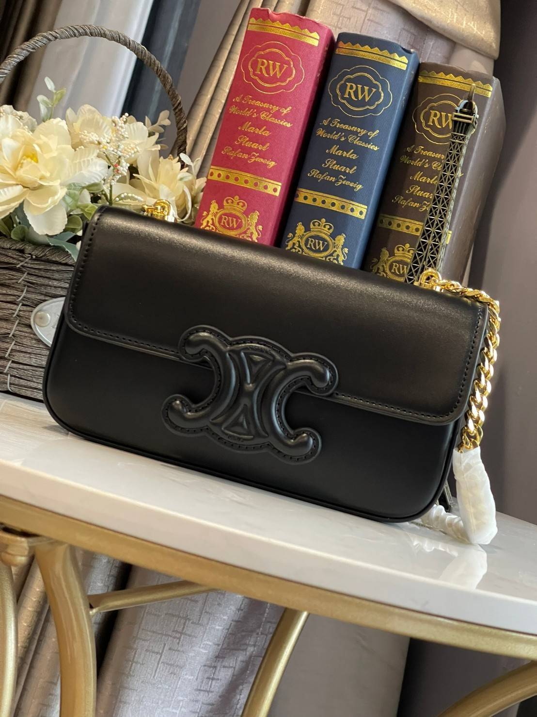 Celine Chain Shoulder Bag Cuir Triompe In Triompe เป็นกระเป๋าถูกประดิษฐ์ขึ้นในรูปทรงมินิมอล นับว่าเป็นกระเป๋าอีกหนึ่งรุ่นในซีรีส์ Triomphe ที่ได้รับความนิยมอย่างมาก โดยเป็นกระเป๋าสะพายไหล่ทรงสี่เหลี่ยมผืนผ้าที่อัดแน่นไปด้วยกลิ่นอายความคลาสสิกตามแบบฉบับของ