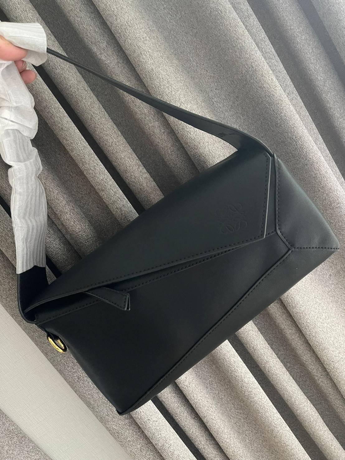 Loewe Puzzle Hobo bag กระเป๋ารุ่น Puzzle มีความพิเศษในหลายด้าน ไม่ว่าจะเป็นรูปทรงที่แปลกใหม่ มินิมอลด้วยโลโก้อนาแกรมแบบประทับ ดูหรู เป็นกระเป๋า Unisex ที่ไม่ว่าคุณจะเป็นผู้หญิงหรือผู้ชายก็ใช้งานได้ ลายกระเป๋าได้มาจากการนำหนังมาเย็บต่อกันทั้งหมด ถึงแม้ว่าข