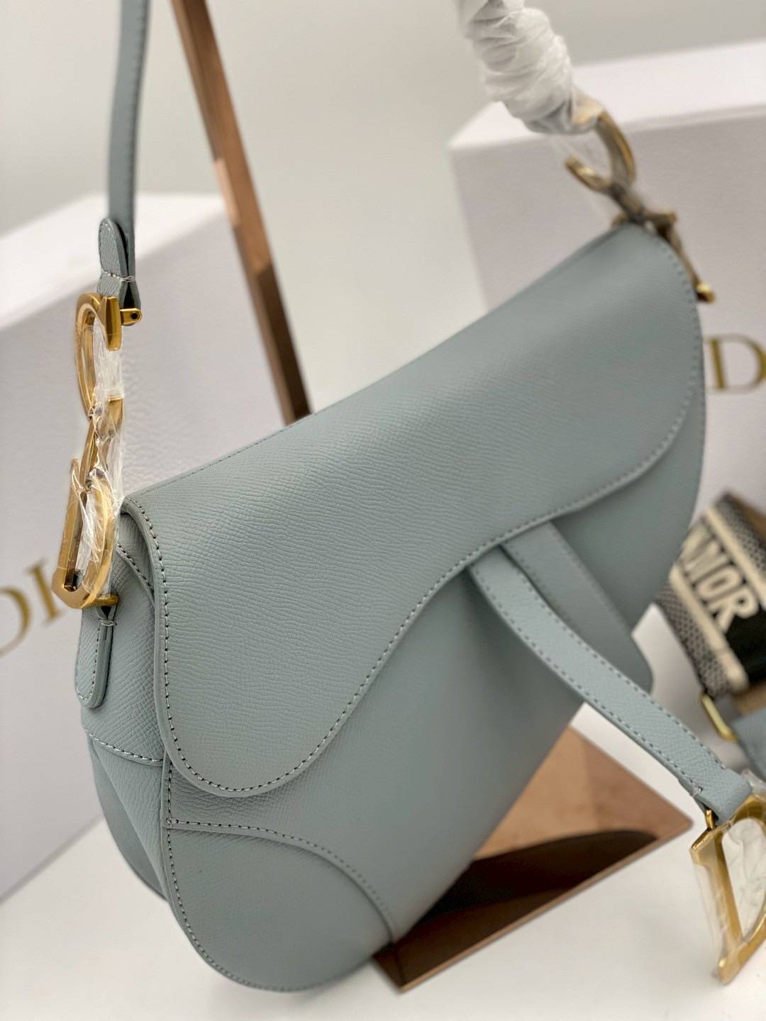 ORI หนังแท้ | DIOR Saddle Bag with Strap Grained Leather กระเป๋าถือ/สะพายทรงอานม้า รุ่นยอดนิยมที่มีเอกลักษณ์สวยงามเหนือกาลเวลา ลูกเล่นห้อยด้วยตัวอักษร D ตรงหูหิ้วมีกิมมิค CD สวยหรูดูแพง