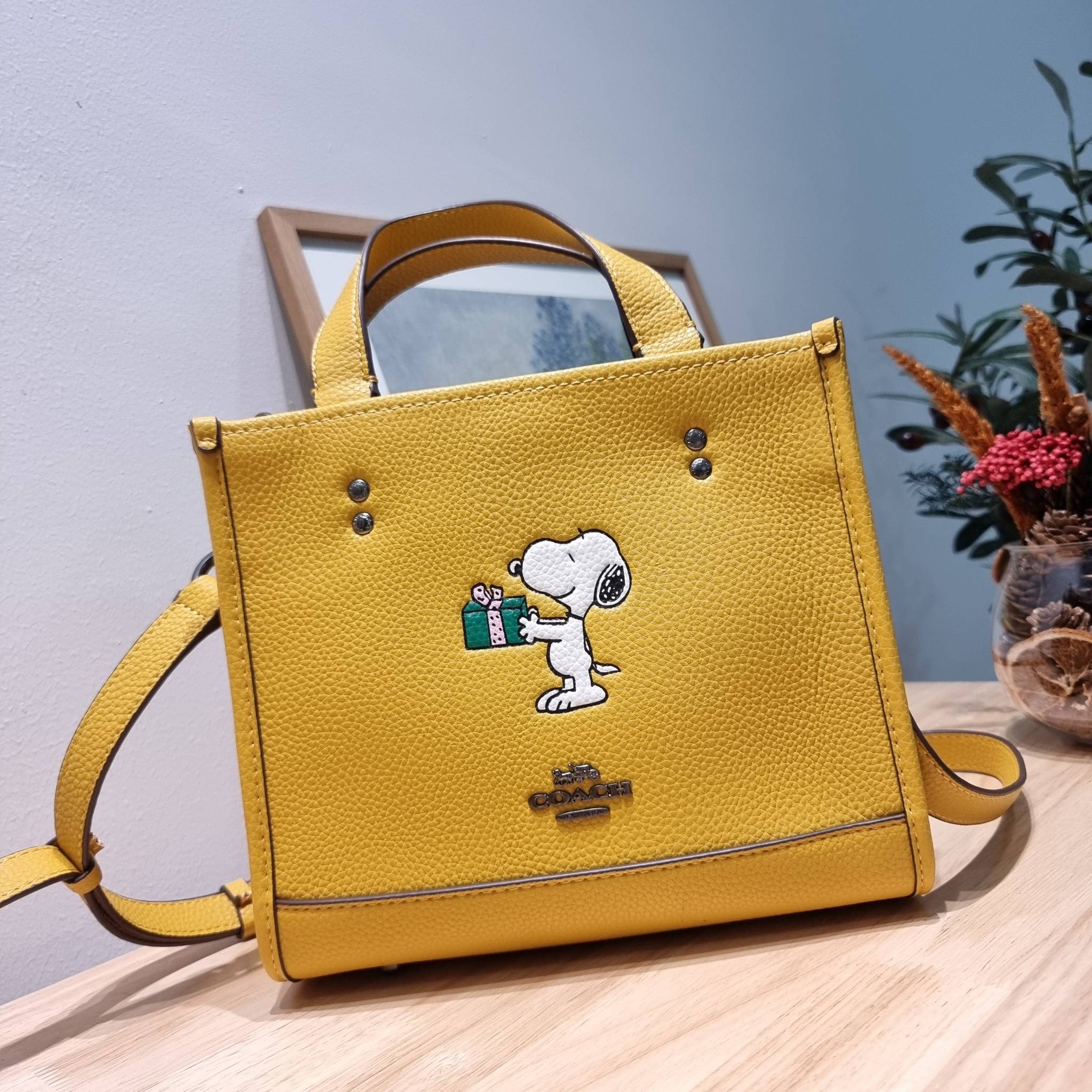 coach x peanuts dempsey tote 22 with snoopy present motif CE918 คอลเลคชั่นใหม่ น้องน่ารักเกินต้านไปมาก!! กับกระเป๋าทรงโท้ท ไซส์กำลังสวย ดีไซน์ ลายการ์ตูนยอดฮิต ที่ใครๆก็ต้องรู้จัก พิมพ์คมชัดลงบนหนัง pepble ผิวสัมน่าใช้ ปากกระเป๋ามีกระดุมแม่เหล็กปิดกันของห