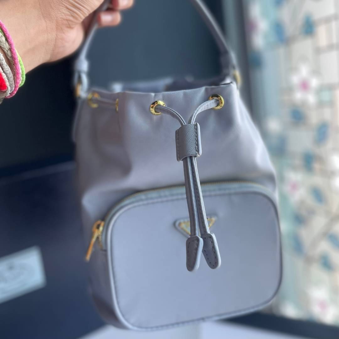 Prada Duet Re-Nylon Bucket shoulder bag / Prada Nylon bucket bag Pastel เกรดใช้สลับใบจริง ออริจินอล ใช้งานต่างประเทศได้ น้องสาวสุดสวยมาให้จับจองอีกหนึ่ง สีพาสเทลน่ารักละมุนมากๆ ค่ะ กระเป๋าสะพายข้าง ทรงขนมจีบ ไซส์มินิ ขนาดน่ารักน่าใช้มาก วัสดุขอบหนังแท้ แล