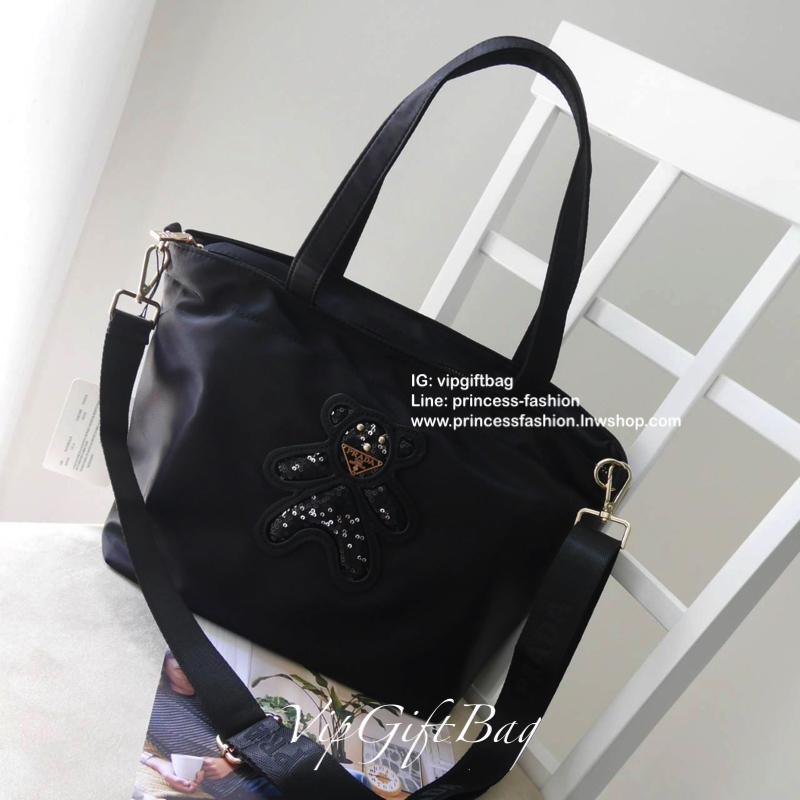 เอาใจคนชอบกระเป๋าไซส์กลาง *มาพร้อมสายยาว สำหรับกระเป๋าอเนกประสงค์ ทรง TOTE จากแบรนด์ PRADA เป็น กระเป๋าผ้าไนล่อน ตามแบบฉบับของแบรนด์เลย ใบนี้มีสายยาวให้ค่ะ เลิศมาก สะพายเป็น shoulder bag หรือ ถือได้คะ ด้านหน้าเป็นลายหมี ปั๊กกลิ้ตเตอร์ + logo brand ใช้แล้ว