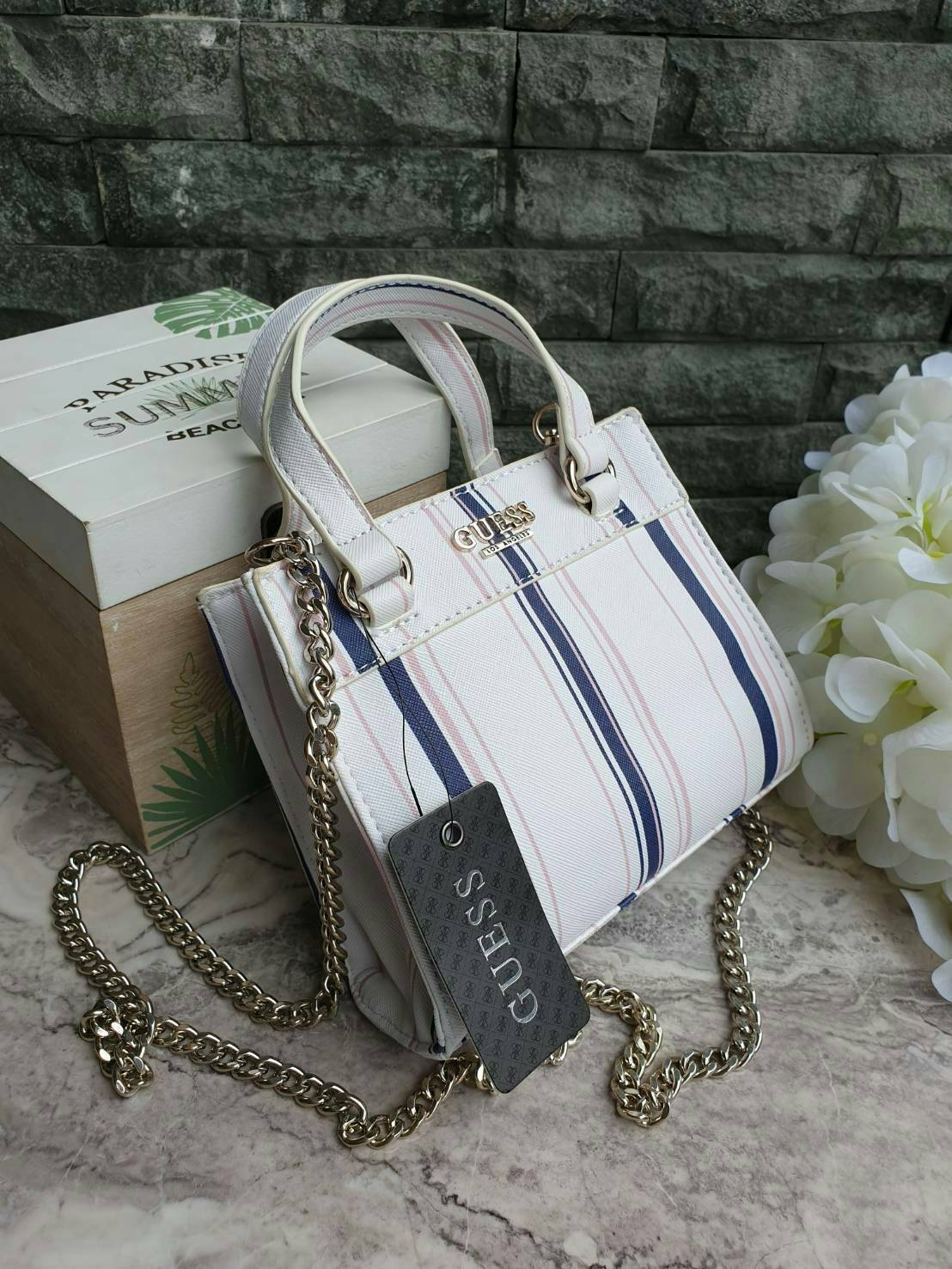 GUESS TAYLOR MINI SATCHEL CROSSBODY BAG กระเป๋าสะพายใบเล็ก สไตล์ สวยหรู คุณหนู ไฮโซ น่ารักมากๆ วัสดุหนังpu เย็บลายตาราง หนังนิ่ม จับนุ่มมือ และ ลายทาง หนัง saffiano ตั้งอยู่ทรง แบบน่ารักไม่ซ้ำใคร ด้านหน้าประดับโลโก้แบรนด์ อะไหล่ทอง มาพร้อมสายโซ่ ถอดออกได้