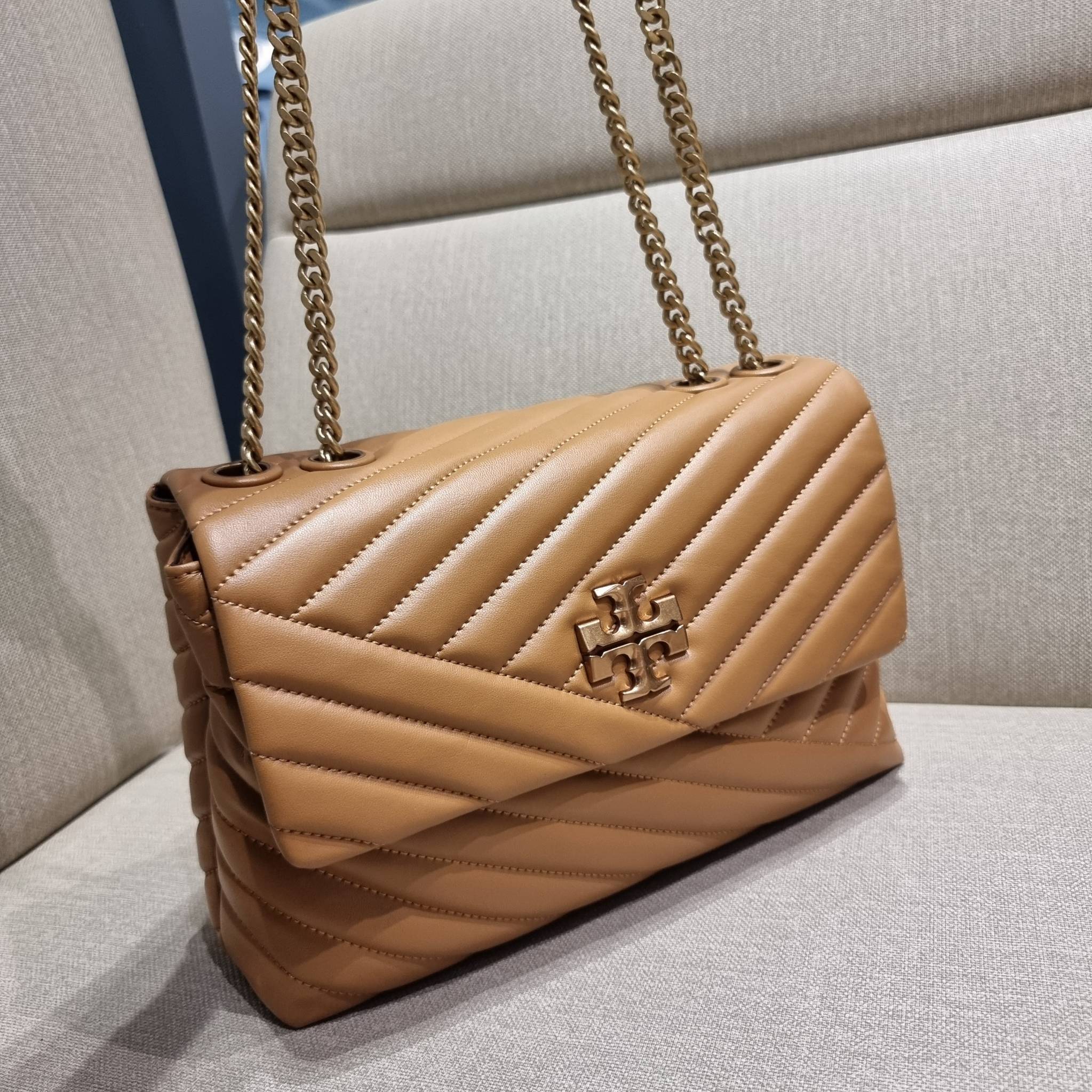 TORY BURCH KIRA CHEVRON CONVERTIBLE SHOULDER BAG กระเป๋าสะพายรุ่นยอดฮิต ไซส์ใหญ่จัดเต็มให้เน้นๆ ใช้ยังไงก็ดูหรู ดีไซน์เฉพาะตัว วัสดุหนังแกะ สัมผัสนิ่ม เปิด-ปิดด้วยกระดุมแม่เหล็ก ภายในเป็นช่องโล่ง แบ่งสัดส่วนไว้ดีมากๆ ใส่กระเป๋าสตางค์ มือถือ เครื่องสำอางค์