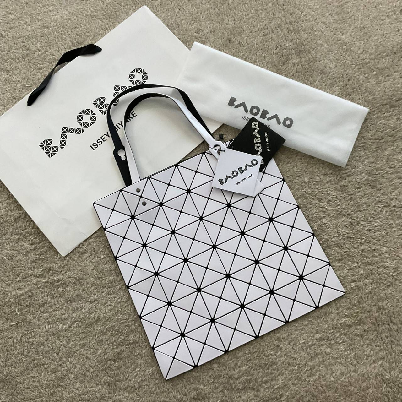 BAO BAO ISSEY MIYAKE TOTE BAG (6x6) กระเป๋าสะพายไหล่ ใบใหญ่ ทรงโท้ท จุดเด่นคือ ปรับได้หลายทรงตามเอกลักษณ์เฉพาะของแบรนด์นี้ ด้านในใส่ของได้เยอะมาก ใส่ไอแพด สมุดโน้ตได้สบายเลย พร้อมช่องซิปใส่ของให้อีกหนึ่งช่อง วัยทำงานหรือวัยนักศึกษา อย่างน้อยต้องมีแบรนด์นี
