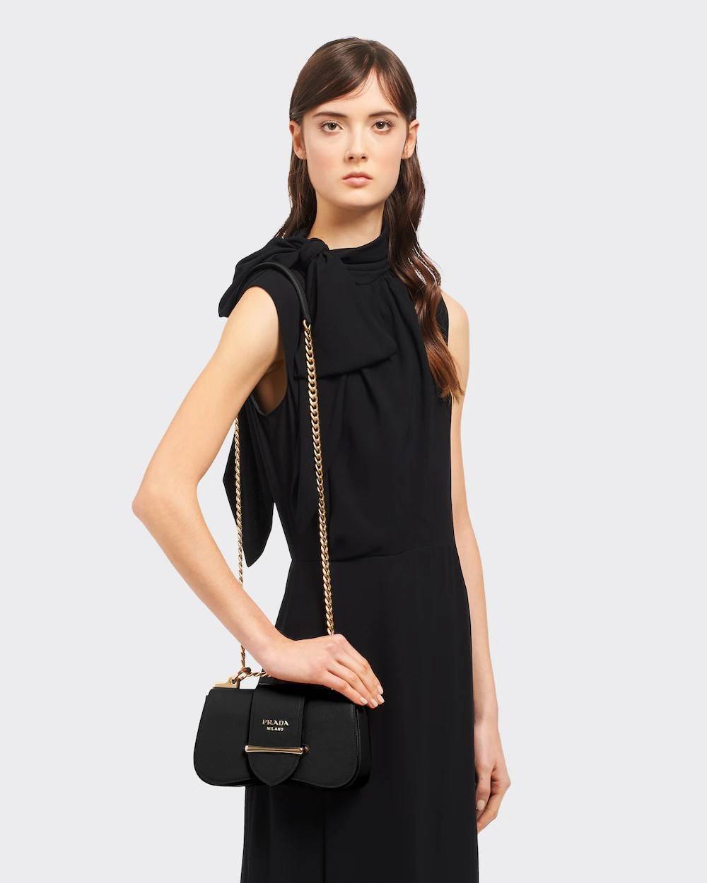 PRADA FRAGRANCE SHOULDER BAG WITH GWP ไอเท็มสุดโปรดที่ควรค่าแก่การครอบครองและเก็บสะสม กระเป๋าสะพายไหล่ สวยคม สีดำคลาสสิคตัดกับอะไหล่ทองเป็นอย่างดี วัสดุหนังแท้เต็มใบ เปิดปิดด้วยแถบหนังสอดในช่อง ใช้งานสะดวก พกพาง่าย ขนาดกำลังสวย สายสะพายในตัว สะพายได้หลากห