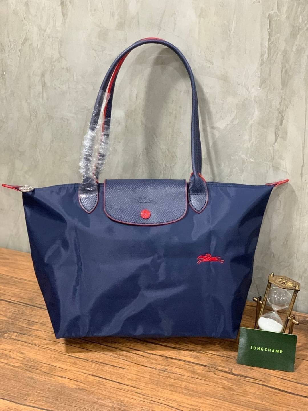Longchamp LE PLIAGE Club (พร้อมส่ง 8 สี) TOTE BAG S กระเป๋ารุ่นยอดนิยม ที่สาวๆ ต้องมีไว้เก็บไว้สักใบ ด้วยตัวน้ำหนักกระเป๋า Longchamp เบาแสนเบา แต่จุของได้เยอะมาก สำหรับลุคทางการกึ่งลำลอง แฝงความสบาย ยามเดินทาง จุดเด่นอย่างหนึ่งของ กระเป๋าก็คือ สามาถพับเก็