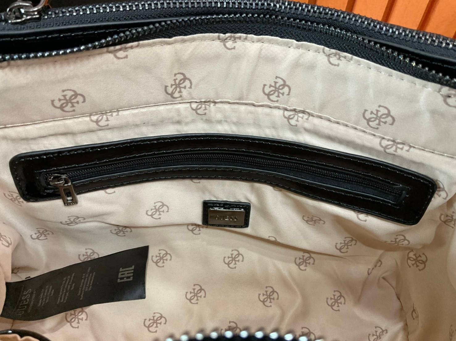 กระเป๋าสะพายไหล่ Guess Logo City Small Society Satchel กระเป๋าสะพายไหล่ ขนาดกำลังดี วัสดุ pu สวยอยู่ทรง มาพร้อมพวงกุญแจน่ารักๆ ถอดออกได้ ด้านหน้าประดับโลโก้แบรนด์ เปิดปิดด้วยซิป มี 2 ช่องหลักใช้งาน ภายในช่องซิปหน้าแยกเป็นสัดส่วนการใช้งาน ซิปช่อง 2 โล่งกว้