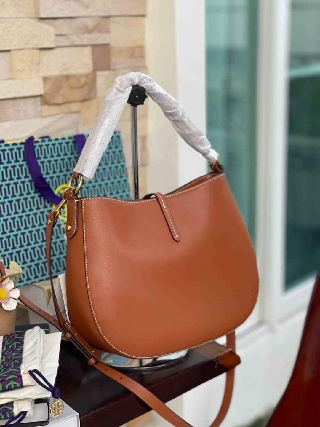 Tory burch miller metal-logo mini hobo bag มีกลิ่นอายสุดคลาสสิก ได้รับแรงบันดาลใจมาจากการขี่ม้า จึงได้ดีไซน์กระเป๋าออกมาในรูปแบบอานหลังม้าสุดเก๋ที่สามารถนำไปมิกซ์แอนด์แมทช์กับสไตล์การแต่งตัวได้หลายชนิด ไม่ว่าจะเป็นกับเดรสทรงยาวหรือกางเกงยีนแสนเท่ตัวโปรดขอ