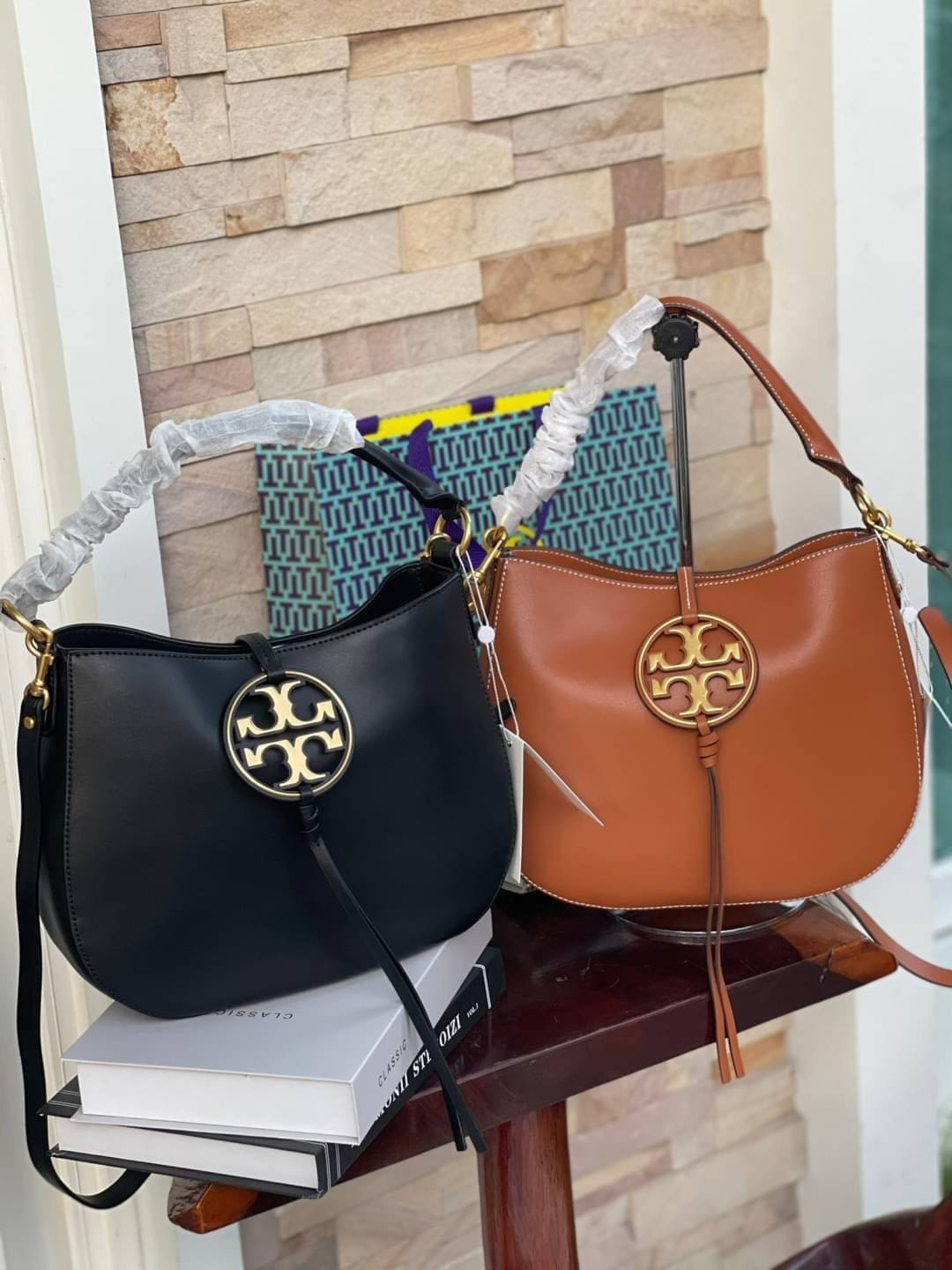 Tory burch miller metal-logo mini hobo bag มีกลิ่นอายสุดคลาสสิก ได้รับแรงบันดาลใจมาจากการขี่ม้า จึงได้ดีไซน์กระเป๋าออกมาในรูปแบบอานหลังม้าสุดเก๋ที่สามารถนำไปมิกซ์แอนด์แมทช์กับสไตล์การแต่งตัวได้หลายชนิด ไม่ว่าจะเป็นกับเดรสทรงยาวหรือกางเกงยีนแสนเท่ตัวโปรดขอ