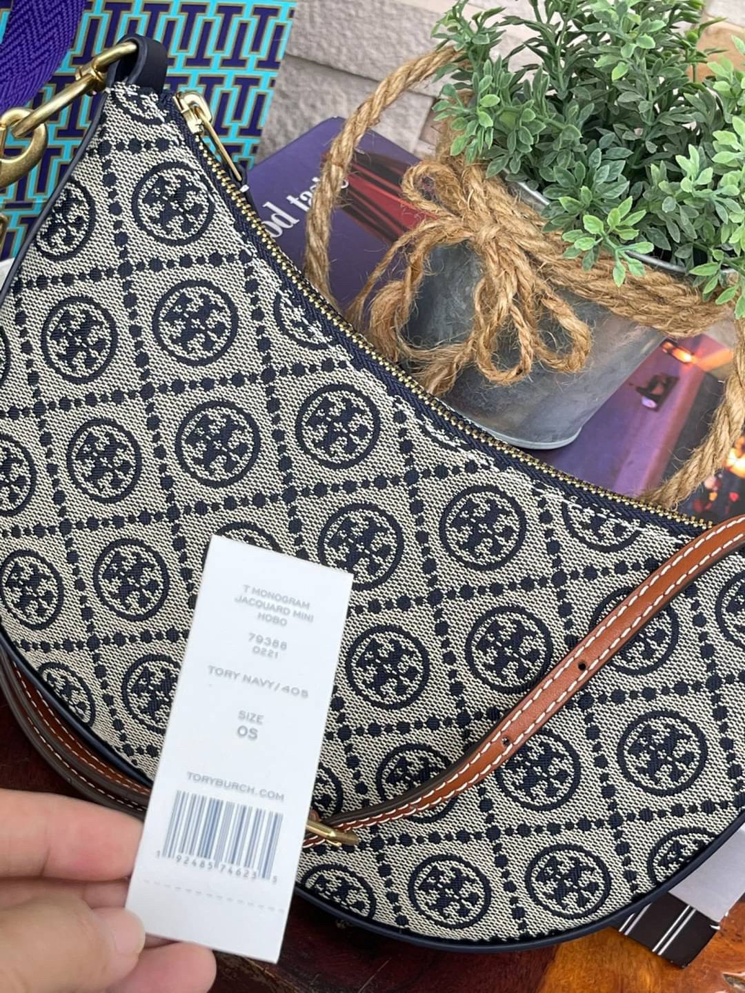 ของแท้ 💯% Tory Burch T monogram jacquard Mini Hobo Bag กระเป๋าลวดลาย T Monogram ใบนี้มาในรูปแบบกระเป๋าทรง Hobo Bag มีความแตกต่างจากกระเป๋าทรงอื่นๆ