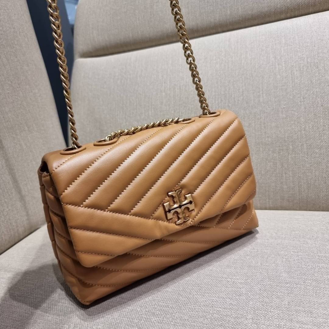 TORY BURCH KIRA CHEVRON CONVERTIBLE SHOULDER BAG (SMALL / MEDIUM) กระเป๋าสะพายรุ่นยอดฮิต ไซส์คลาสสิค ที่ใช้ยังไงก็ดูหรู ดีไซน์เฉพาะตัว วัสดุหนังแกะ สัมผัสนิ่ม เปิด-ปิดด้วยกระดุมแม่เหล็ก ภายในเป็นช่องโล่ง ใส่กระเป๋าสตางค์ มือถือ เครื่องสำอางค์ พาวเวอร์แบงค