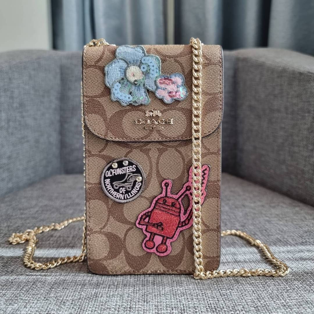 COACH NORTH/SOUTH PHONE CROSSBODY IN SIGNATURE CANVAS F55636 F39955 สุดคลาสสิคกับกระเป๋าสะพายเอนกประสงค์ Case phone ใส่โทรศัพท์มือถือได้ทุกรุ่น ดีไซน์ลายเอกลักษณ์ วัสดุหนังแคนวาสเคลือบลาย ฝาและภายในเป็นหนังสังเคราะห์เรียบ เปิด-ปิดด้วยกระดุม สายสะพายยาวประ