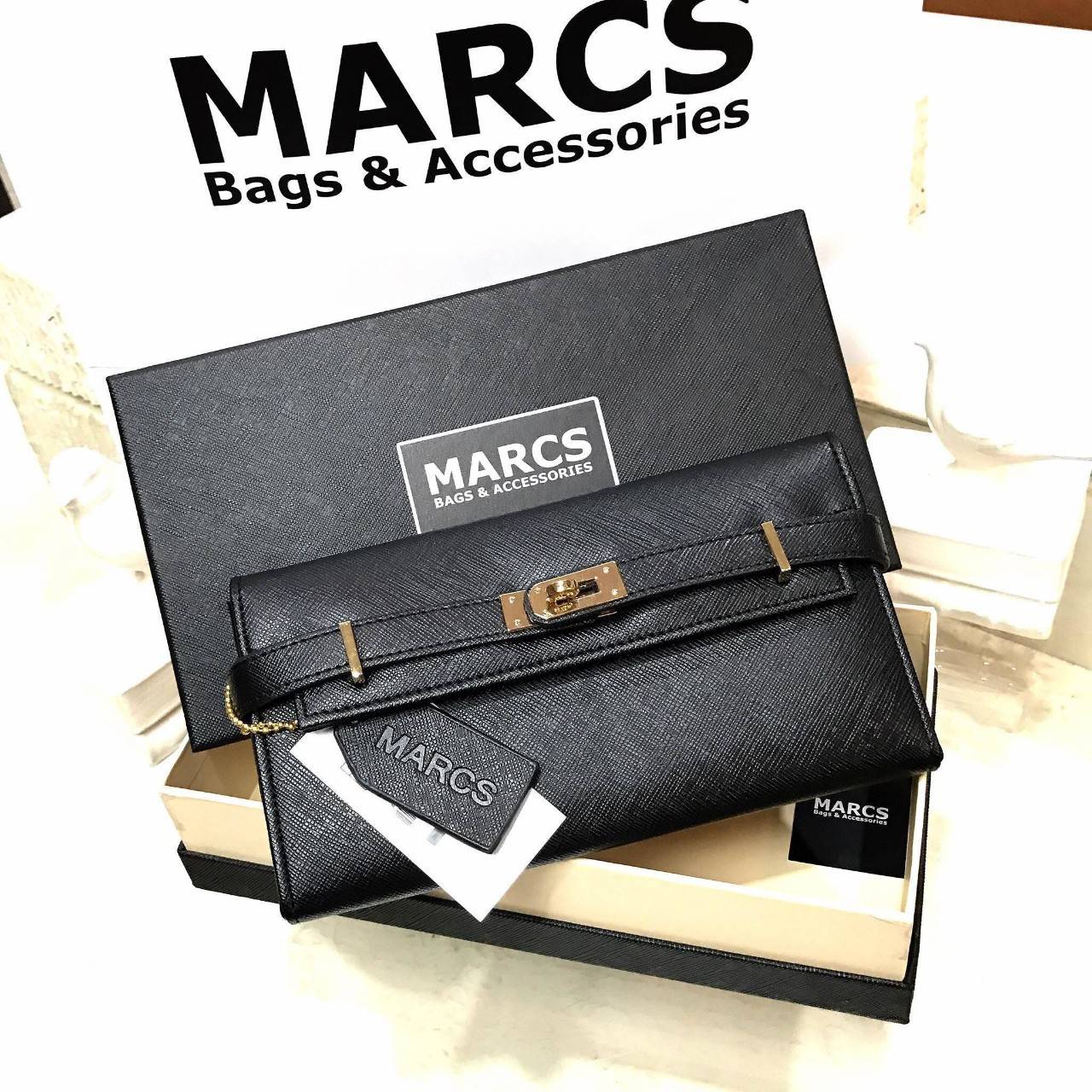 พร้อมส่งความสวย! NEW ARRIVAL! MARCS PADLOCK LONG WALLET กระเป๋าสตางค์ใบยาววัสดุหนัง Saffiano สวยหรูโดดเด่นด้วยสายหนังรัดกระเป๋าด้านหน้าสไตล์ Birkin ภายในมีโลโก้และมีช่องแบ่งหลายช่องเป็นสัดส่วนช่องใส่บัตรหลายช่อง มีช่องซิปสำหรับใส่เหรียญ ใส่ธนบัตร และ ipho