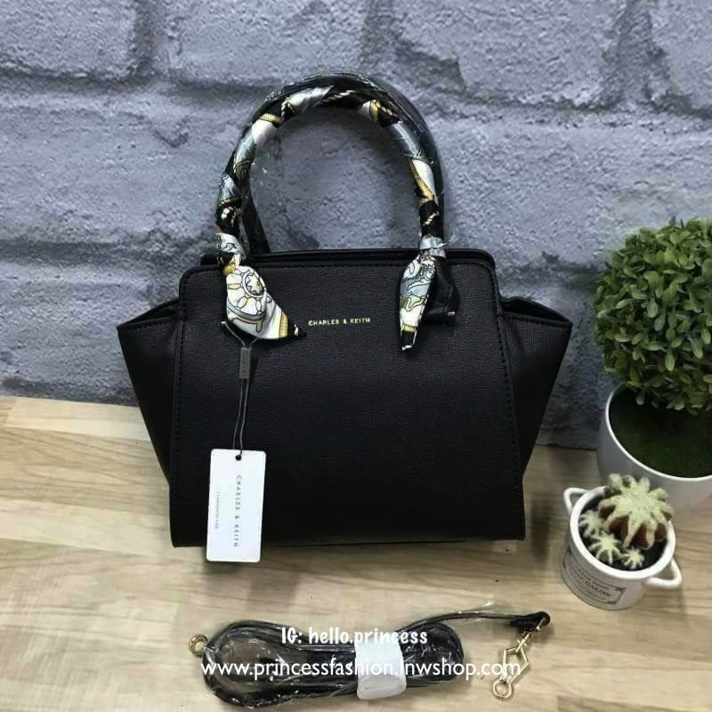 CHARLES&KEITH MINI TRAPEZ BAG พร้อมส่งรุ่นฮิตในตำนานรุ่นขายดี !! !กระเป๋าถือหรือสะพายหนังsaffiano พร้อมสายสะพายยาว115cmปรับความยาวได้5ระดับ ด้านล่างมีหมุดรองฐาน ทั้ง4มุม หูจับสูง14cmมีผ้าพันรอบสามารถถอดออกได้ ลายและสีสวยงามเข้ากับกระเป๋า ขนาดกำลังดีและน้ำ
