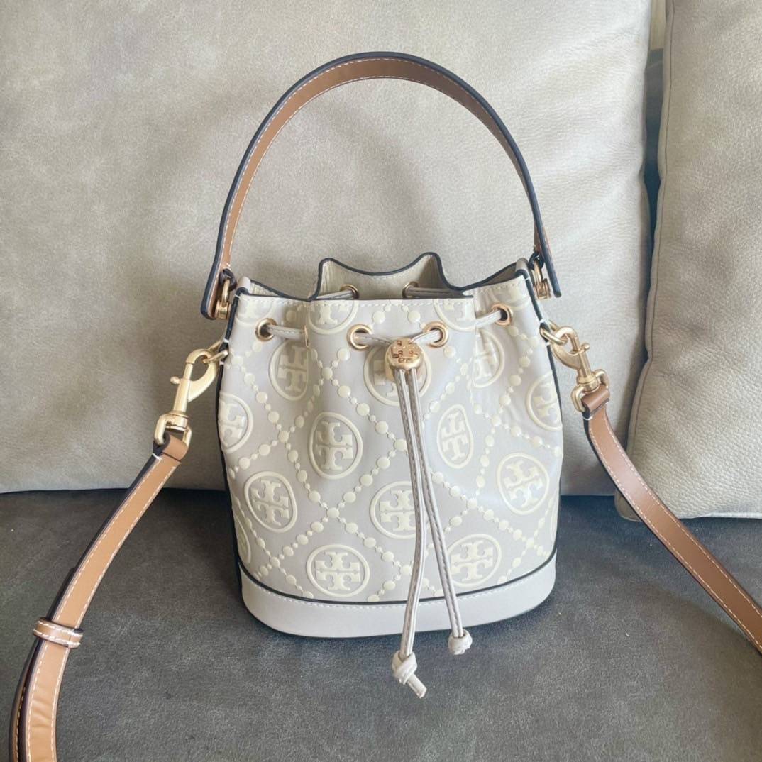 Medium : Tory Burch T Monogram Embossed Bucket Bag กระเป๋าถือหรือสะพายไหล่ ประดับด้วยลวดลายอันเป็นสัญลักษณ์ของแบรนด์ ถูกประดิษขึ้นด้วยความพิถีพิถันวัสดุหนังอย่างดี ด้านในบุด้วยหนังไมโครซูแอคเนื้อนุ่มทำความสะอาดง่าย กระเป๋าผ่าหลังด้านนอก1ช่อง ด้านใน 1ช่อง 