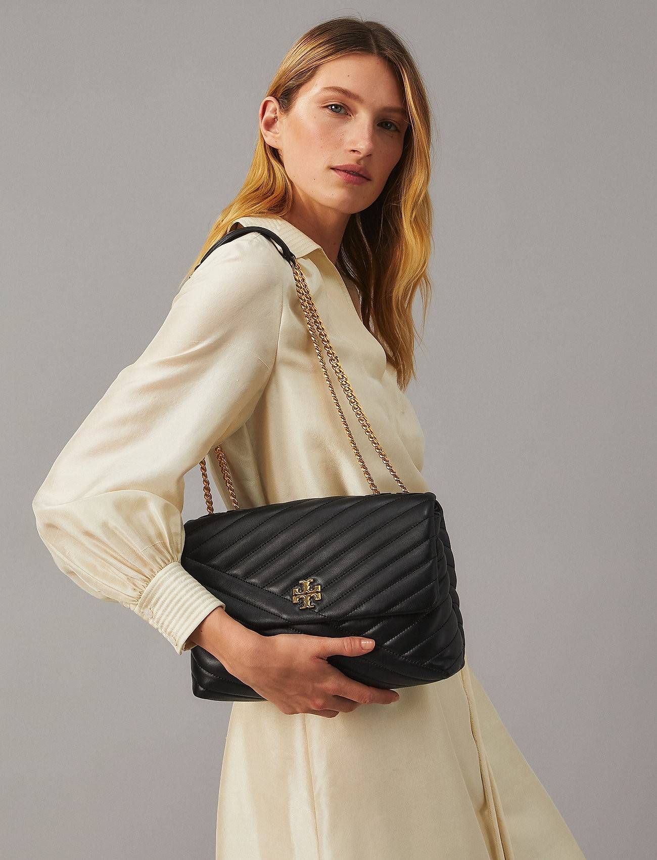 TORY BURCH KIRA CHEVRON CONVERTIBLE SHOULDER BAG กระเป๋าสะพายรุ่นยอดฮิต ไซส์ใหญ่จัดเต็มให้เน้นๆ ใช้ยังไงก็ดูหรู ดีไซน์เฉพาะตัว วัสดุหนังแกะ สัมผัสนิ่ม เปิด-ปิดด้วยกระดุมแม่เหล็ก ภายในเป็นช่องโล่ง แบ่งสัดส่วนไว้ดีมากๆ ใส่กระเป๋าสตางค์ มือถือ เครื่องสำอางค์