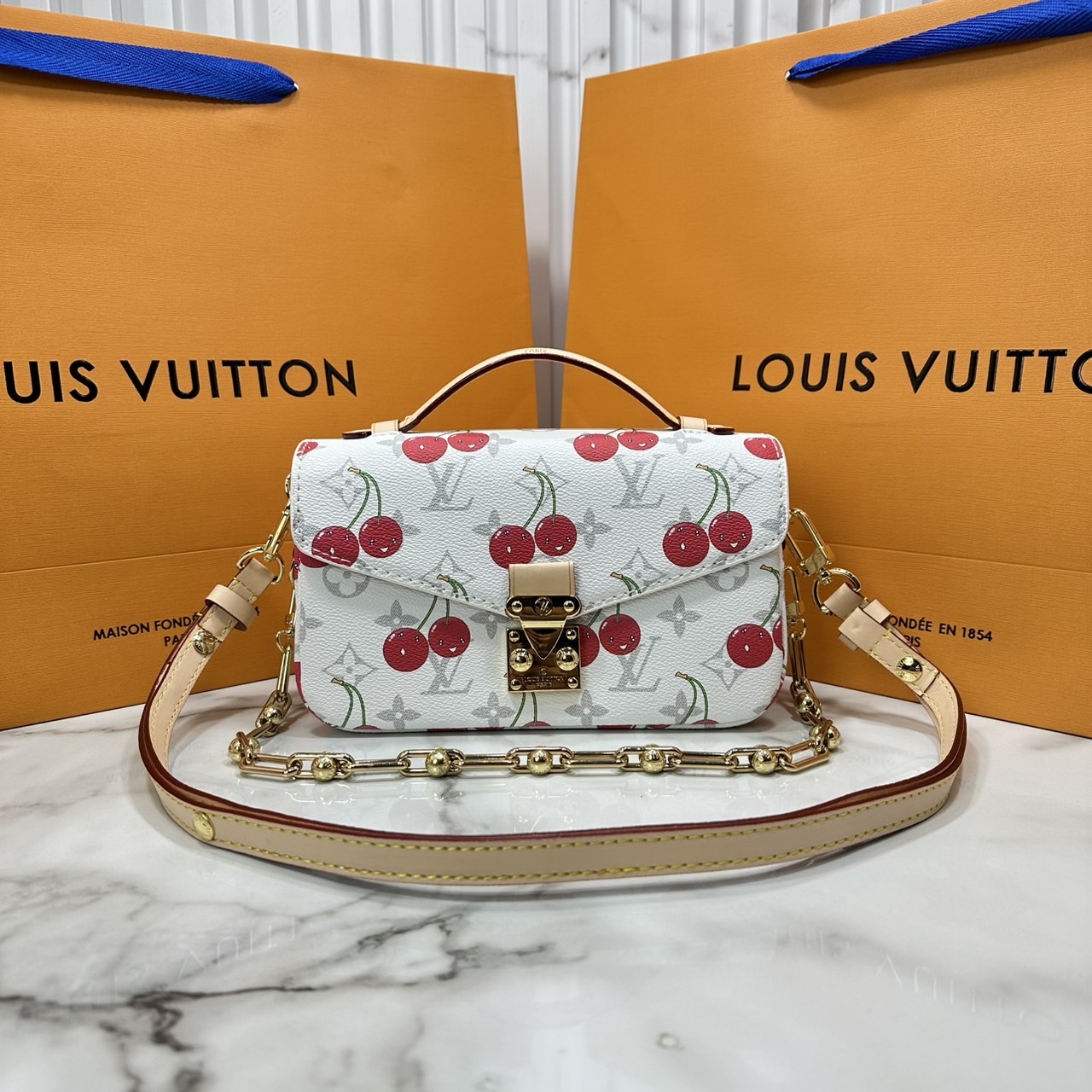 ORI หนังแท้ | LV x TM Pochette Métis East West Monogram cherry canvas กระเป๋าสะพาย ดีไซน์ใหม่โทนสีขาวในเฉดสีฤดูร้อนซึ่งตัดกับลวดลายเชอร์รี่สดใสที่ได้รับแรงบันดาลใจจากศิลปินชาวญี่ปุ่นได้อย่างสง่างาม