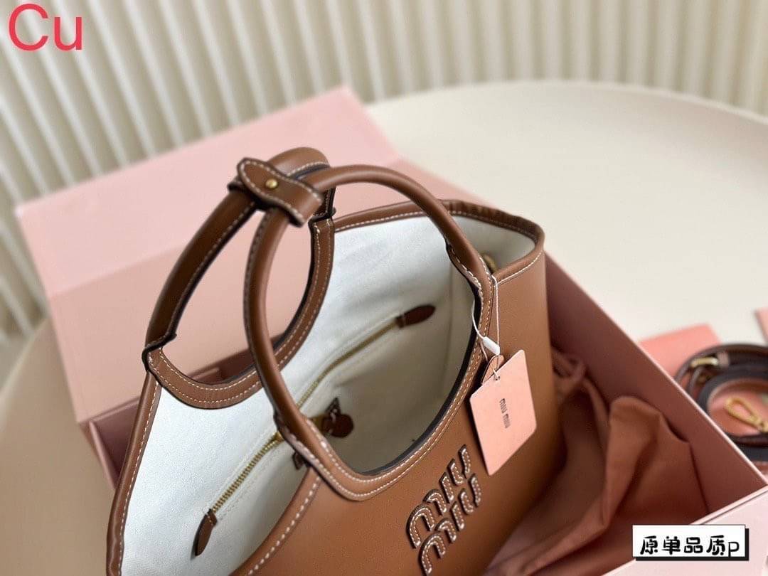 MIU MIU Ivy Leather Tote Bag กระเป๋าถือทรงโท้ทงานหนังเรียบเต็มใบ เรียบหรู มีความยูนิค จับแมตช์ง่าย สวยงามได้หลายสไตส์ ภายในโล่งกว้าง จุของได้เยอะ ใบจริงสวยเกินเบอร์จ้า
