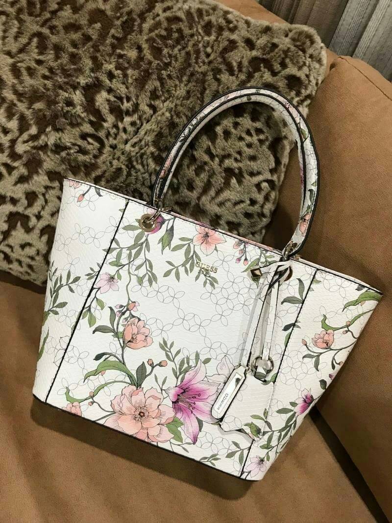 GUESS PRINTED KAMRYN FLOWERS SHOPPER BAG (SIZE L) กระเป๋าสะพายจาก GUESS FACTORY หนังสวยอยู่ทรงปริ้นลายดอกไม้คอลเลคชั่นล่าสุดใบใหญ่กำลังดี ใส่สัมภาระได้จุใจ น้ำหนักเบา ด้านหน้าประดับโลโก้แบรนด์อะไหล่เงินพร้อมพวงกุญแจแบรนด์ห้อยที่หูหิ้วถอดเเยกใช้ได้ หูหิ้วพ