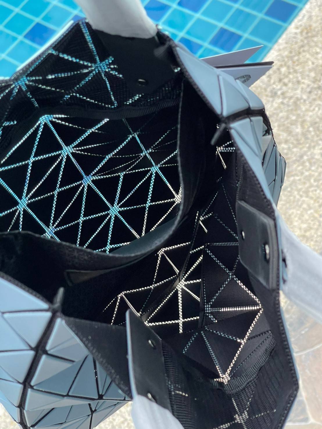 Baobao Issey Miyake Prism Kangaroo tote bag กระเป๋าถือทรงโท้ทที่ประดิษฐ์ขึ้นอย่างเชี่ยวชาญในญี่ปุ่น มาพร้อมแผงเรขาคณิตสำหรับการออกแบบที่ได้รับแรงบันดาลใจจากกระดาษพับ ซิลลูเอทอันเป็นเอกลักษณ์นี้ปิดท้ายด้วยสายรัดแบบอสมมาตร มีการพัฒนาโครงสร้างทรงสามเหลี่ยมเพ