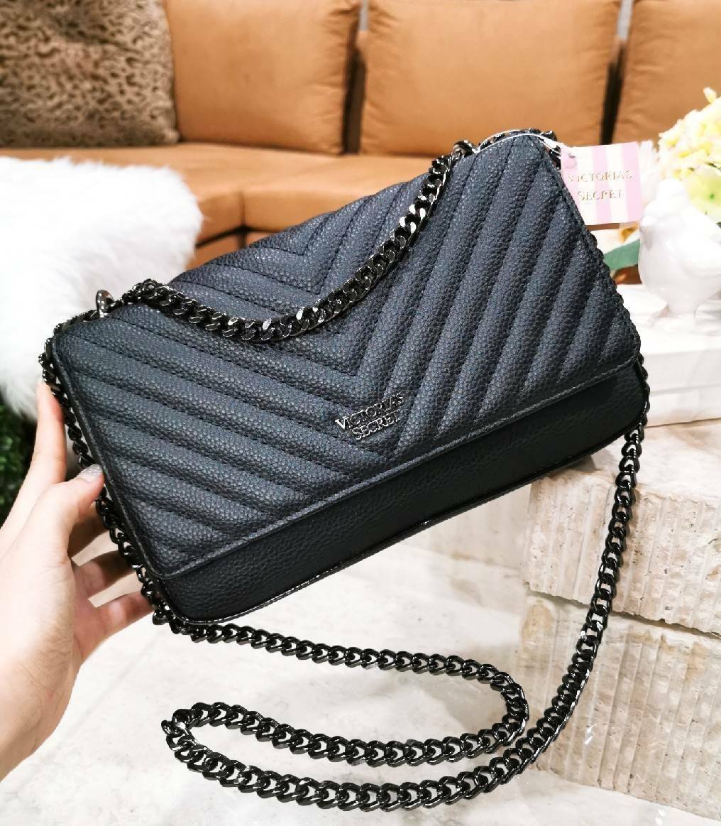 VICTORIA'S SECRET Quilted Chain Crossbody Sling Bag กระเป๋าสะพายรุ่นใหม่ล่าสุดจาก Victoria's Secret วัสดุหนังแกะสังเคราะห์ชึ้นลายริ้วหนังสวยอยู่ทรงไม่ย้วยดีไซน์สุดหรูคุณหนูไฮโซ เปิดปิดด้วยฝาปิดกระดุมแม่เหล็ก ภายในมีโลโก้และช่องใส่ของ ใส่กระเป๋าส
