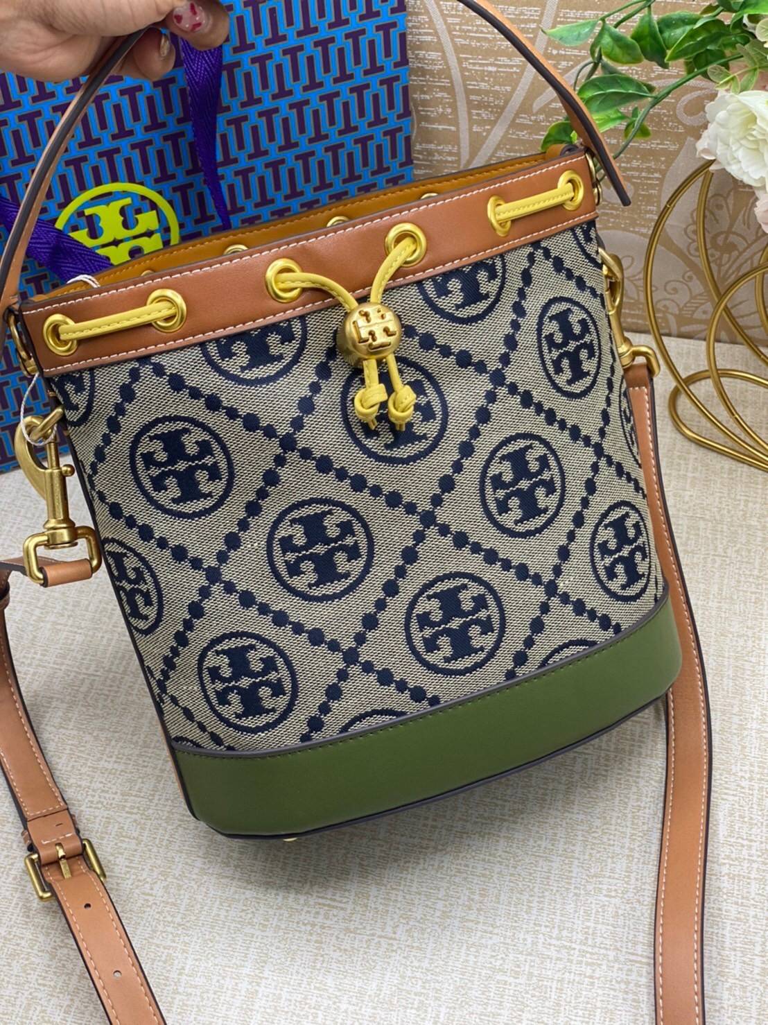 Tory Burch T Monogram Colorblock Bucket Bag กระเป๋าสะพาย ทรงบัคเกต รุ่นฮอต สไตล์ไหนเข้าได้ทุกลุค วัสดุ jacquard ตัดขอบหนังแท้ ภายในเป็นช่องโล่งกว้าง ใส่ของได้เยอะหยิบจับสะดวก มาพร้อมสายสะพายข้างหนังแท้ ถอดและปรับระดับได้สะพายชิวได้ทุกโอกาส