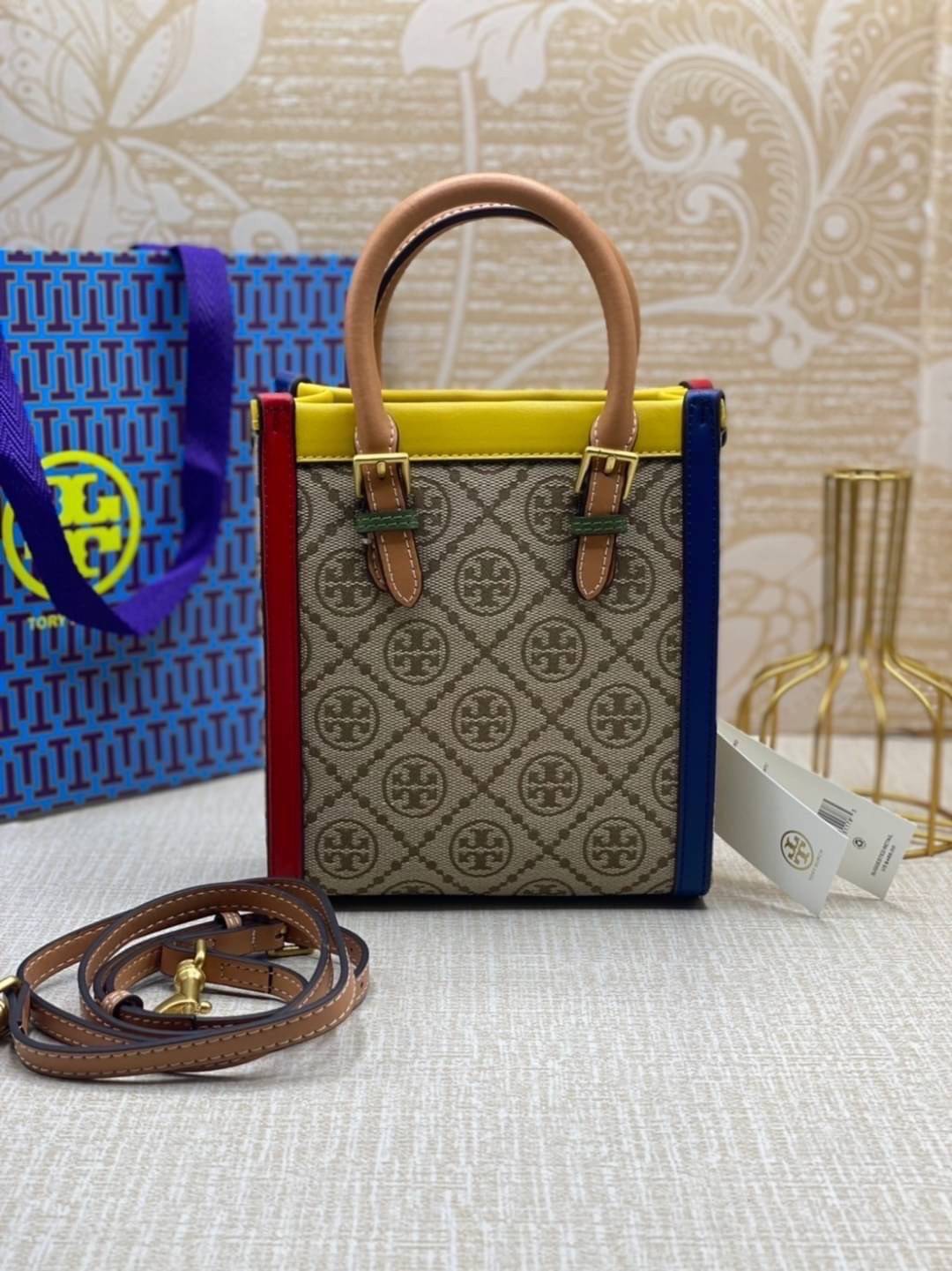TORY BURCH T MONOGRAM COLORBlOCK JACQUARD MINI TOTE คอลเลคชั่นใหม่ล่าสุด ครอบครองก่อนใคร ไอเท็มยุคนี้รุ่นที่ควรมีติดตู้คะสาวๆ วัสดุ jacquard สลับหนังแท้ หูจับ มาพร้อมสายสะพายข้างหนังแท้ ปรับระดับได้ สายสามารถถอดออกได้ ภายในเป็นช่องโล่ง ใส่มือถือได้ กระเป๋