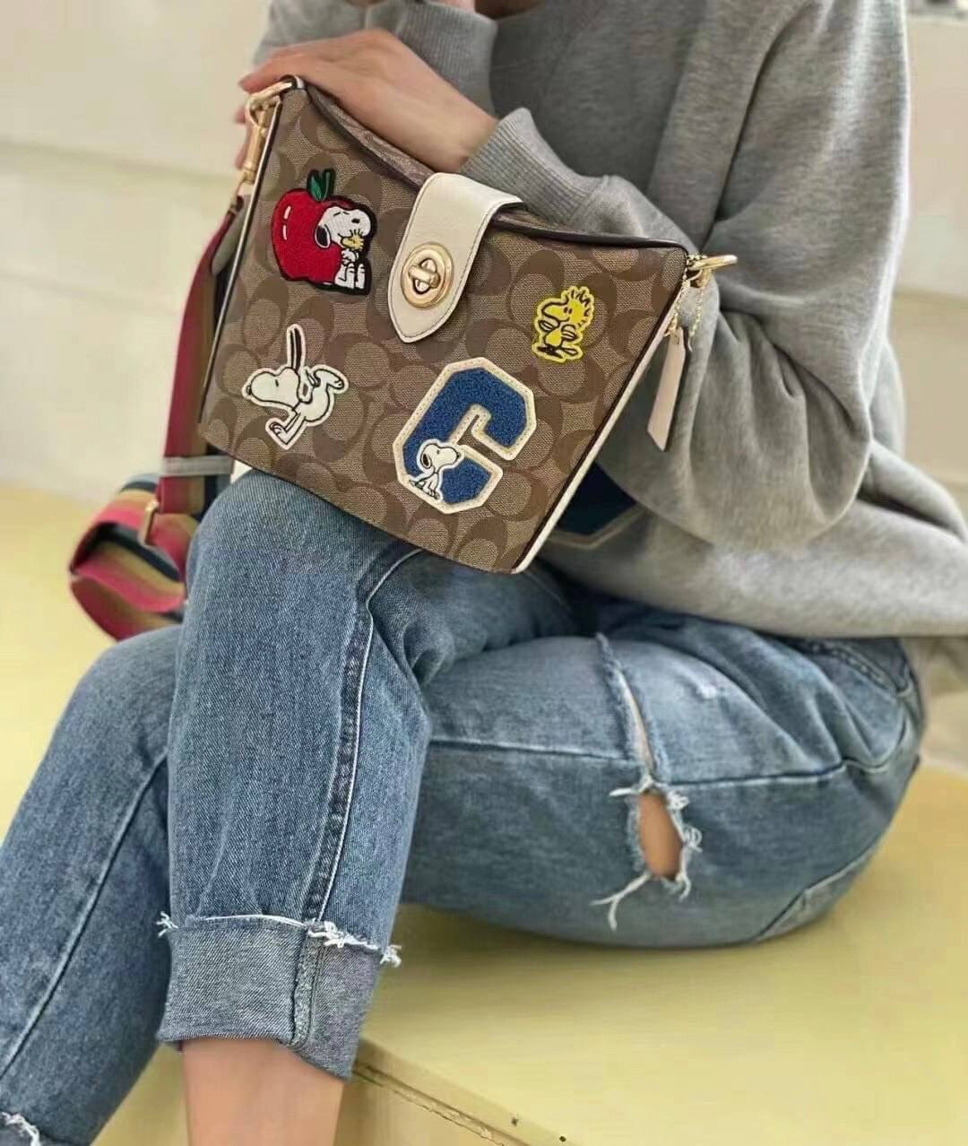 COACH C4113 - COACH X PEANUTS ADDIE CROSSBODY IN SIGNATURE CANVAS WITH VARSITY PATCHES พร้อมส่งทันที่! ลิมิเตทจาก Coach x Peanuts ที่รังสรรค์ลวดลายการ์ตูนลงบนกระเป๋าได้ซุกซนน่ารักดีมากๆค่ะ