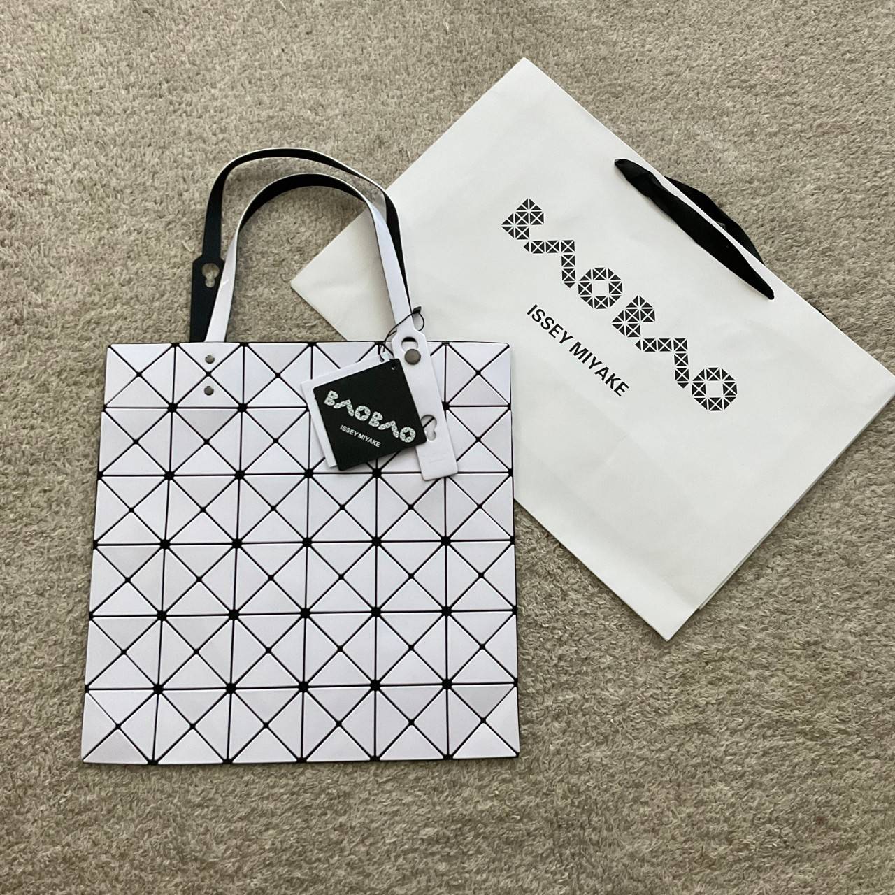 BAO BAO ISSEY MIYAKE TOTE BAG (6x6) กระเป๋าสะพายไหล่ ใบใหญ่ ทรงโท้ท จุดเด่นคือ ปรับได้หลายทรงตามเอกลักษณ์เฉพาะของแบรนด์นี้ ด้านในใส่ของได้เยอะมาก ใส่ไอแพด สมุดโน้ตได้สบายเลย พร้อมช่องซิปใส่ของให้อีกหนึ่งช่อง วัยทำงานหรือวัยนักศึกษา อย่างน้อยต้องมีแบรนด์นี