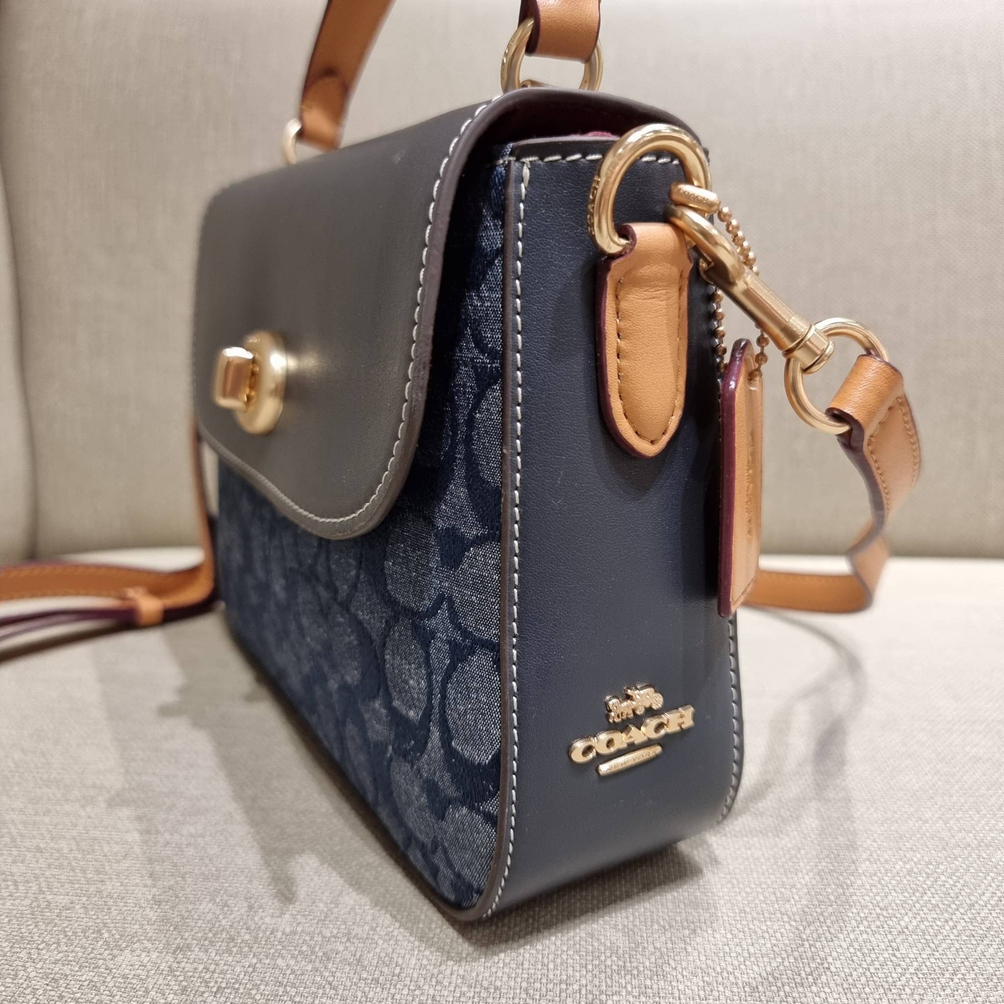 COACH C4921 MARLIE TOP HANDLE SATCHEL IN SIGNATURE CHAMBRAY กระเป๋าถือ/สะพายข้าง มีดีไซน์ยูนีค โดดเด่น ตกแต่งโลโก้ด้านข้างอะไหล่ทอง วัสดุผ้าแชมเบรย์ ทอเส้นลายสวย เปิด-ปิดด้วยตัวล็อคแน่นหนา ภายในเป็นช่องโล่ง ใส่ของได้ครบครัน มาพร้อมหูจับในตัวและสายสะพายข้า