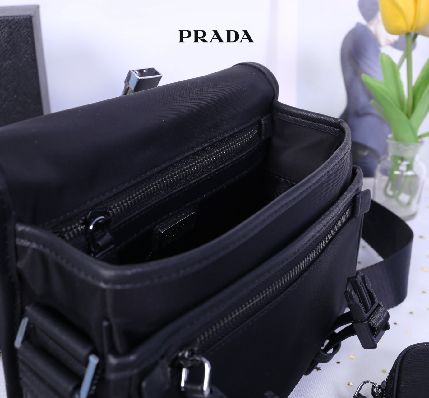 Prada Nylon and Saffiano Leather Bag with Strap กระเป๋าสะพายแบบ Crossbody ใช้ได้ทั้งหญิงชาย มาพร้อมกระเป๋าใส่เหรียญใบเล็กน่ารัก เปิด-ปิดด้วยตัวล็อค ด้านในยังแบ่งช่องเป็นสัดส่วน จุของได้เยอะ ซับในด้วยผ้าพิมพ์ลายแบรนด์อย่างดี และยังมี 1 ช่องซิปด้านหลัง สายส