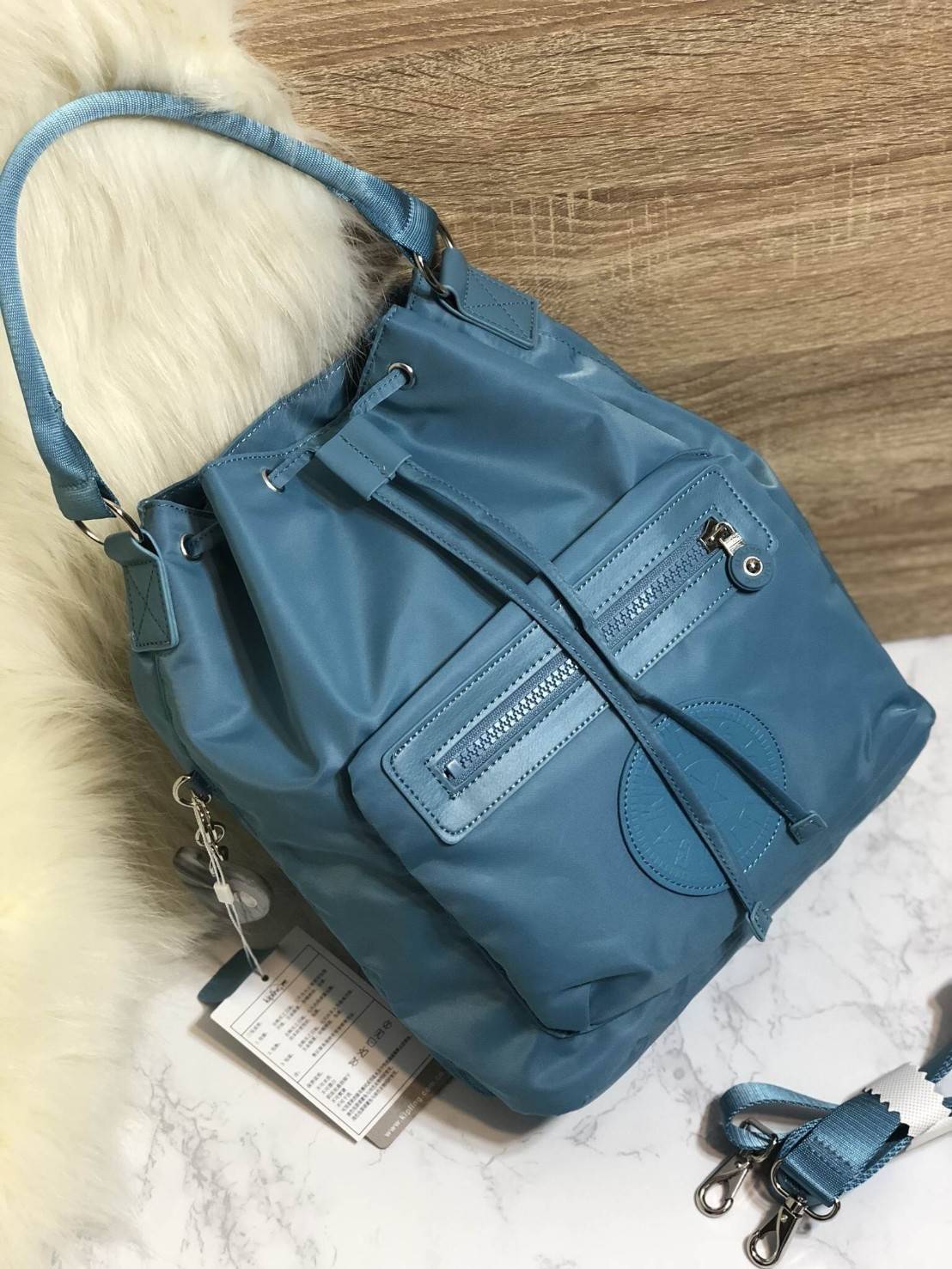 Kipling 2Way Bucket Bag กระเป๋าถือหรือสะพาย 2Way รุ่นใหม่ทรงขนมจีบวัสดุ Nylon & Polyester 100% น้ำหนักเบา ถือและสะพายได้หลายแบบจะใช้สายยาวสะพาย Crossbody หรือใช้สายคู่สะพายหลังแบบเป้ก็ดูดี หูจับถนัดมือสะพายไหล่ได้ เปิดปิดแบบ Drawstring พร้อมกระดุมแม่เหล็ก