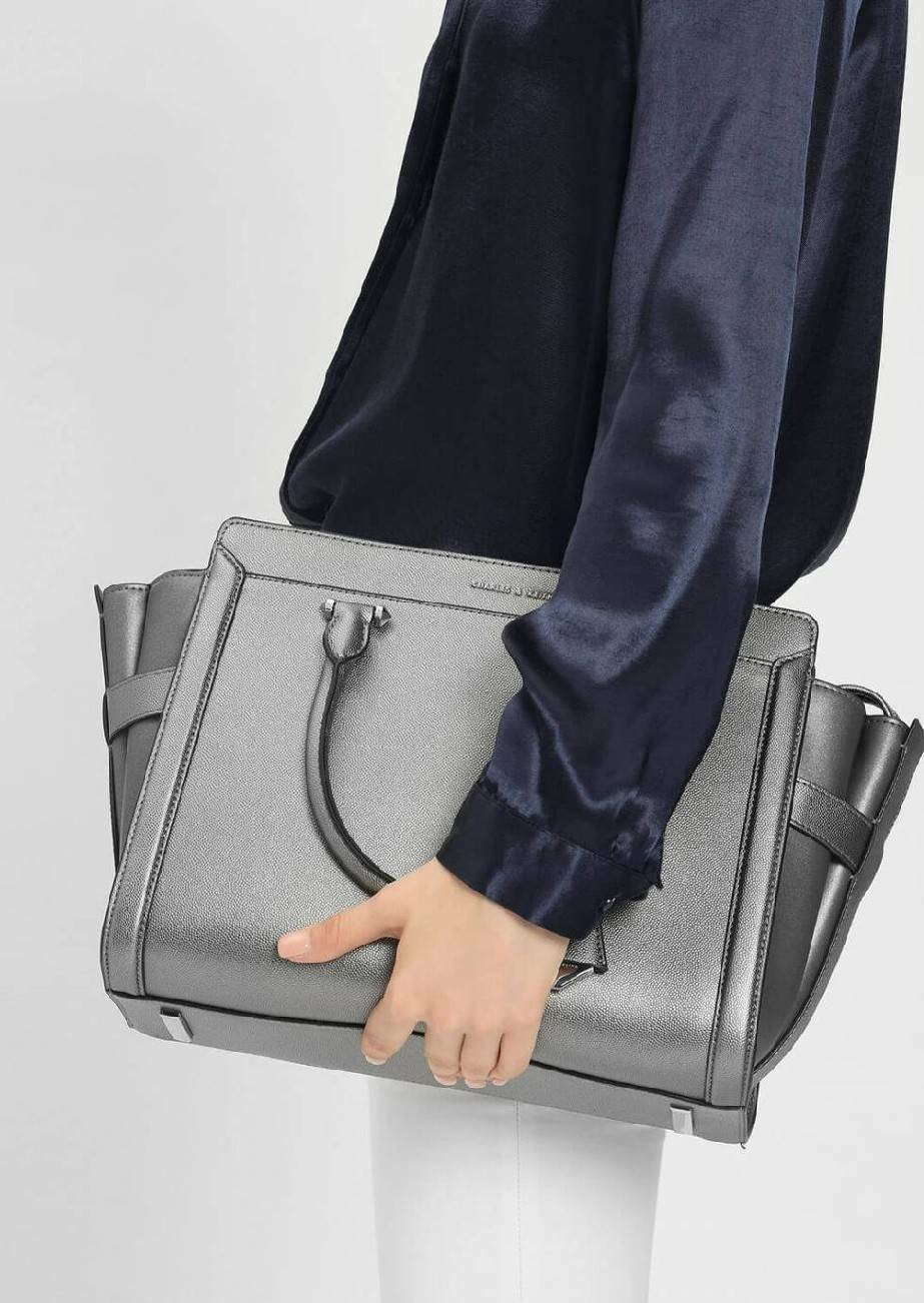 CHARLES & KEITH SAFFIANO TRAPEZE BAG กระเป๋าถือหรือสะพายรุ่นยอดนิยมดีไซน์สวยหรูวัสดุหนังคาเวียร์อยู่ทรง ด้านข้างเเต่งหนังช่องตัดดูมีดีเทล ด้านหน้ามีโลโก้ ด้านหลังมีช่องซิป เปิดปิดด้วยซิปหัวซิปแบรนด์ หูจับเเข็งแรง พับลงได้ พร้อมสายสะพายหนังปรับระดับได้ถอดไ