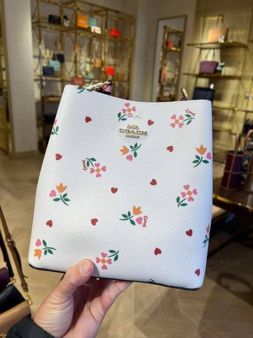 COACH C7976 SMALL TOWN BUCKET BAG WITH HEART PETAL PRINT 💕💜💕💝 คอลเลคชั่นใหม่ล่าสุด ที่พร้อมให้สาวๆได้สวยในเทศกาลแห่งความรัก กระเป๋าทรงบัคเก็ตไซส์เล็ก ดีไซน์ลวดลายสุดคิ้วท์ ช่อดอกไม้หัวใจ เห็นแล้วต้องปิ๊ง!! วัสดุหนัง pepble 