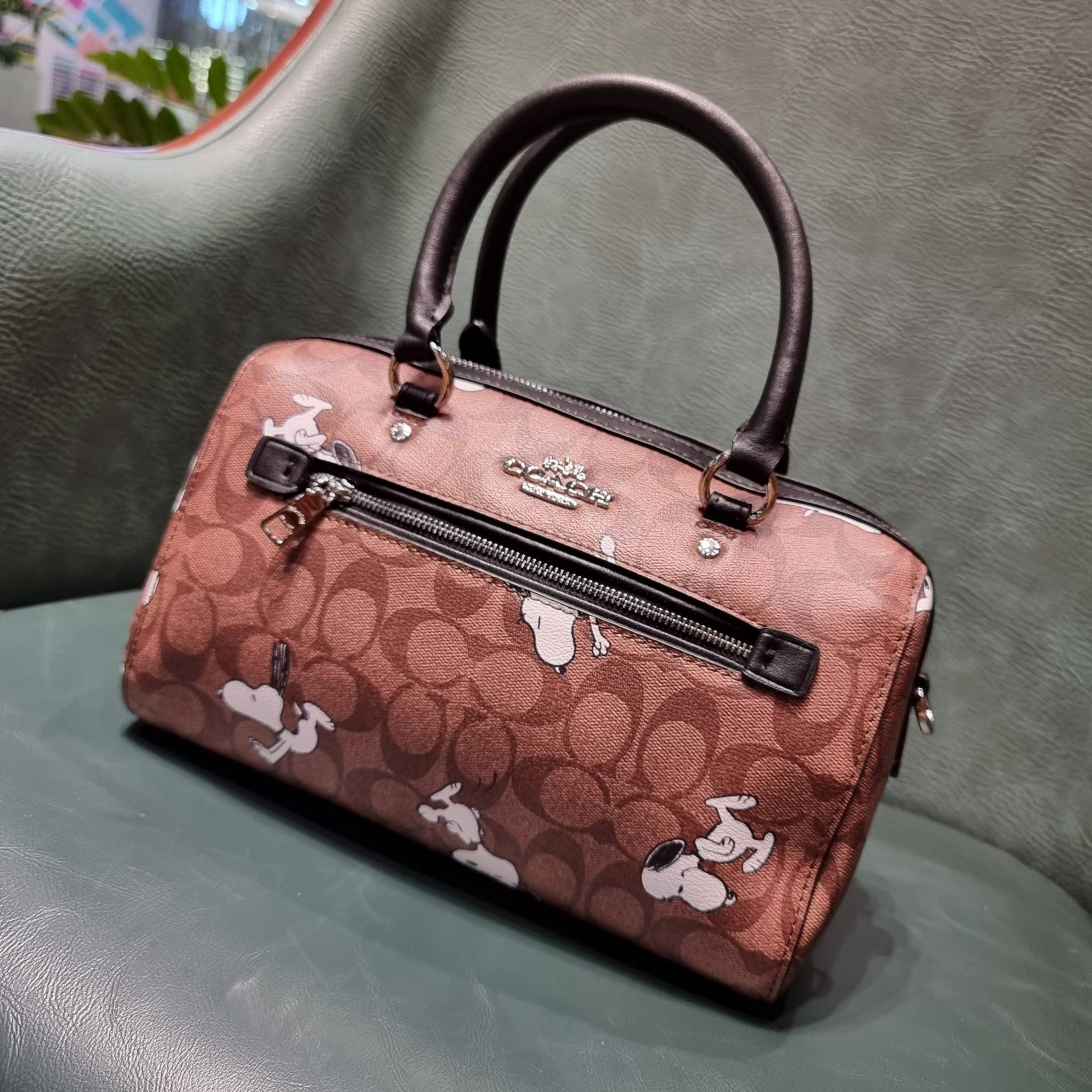 COACH C4118 COACH x PEANUTS ROWAN SATCHEL IN SIGNATURE CANVAS WITH SNOPPY PRINT สนูปพีที่สุดของคอลเลคชั่นแห่งความน่ารัก มาในดีไซน์ของกระเป๋าทรงหมอนยอดฮิต คลาสสิคใช้งานได้ไม่มีเบื่อ รอบนี้มาให้พร้อมสายสะพาย crossbody แบบสปอร์ต ทำให้ใช้งานได้อย่างกระฉับกระเ