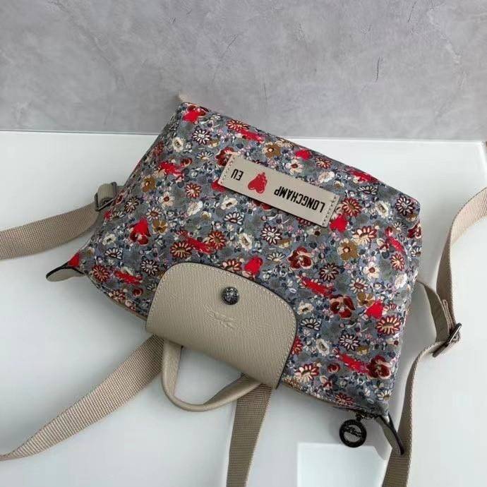 Longchamp X Eu Backpack กระเป๋าเป้สะพายหลังลายดอกๆไม้ วัสดุผ้าฝ้าย อะไหล่สีดำ กระเป๋าเป้แบบลำลองสำหรับสตรีซึ่งนำรูปทรงอันเป็นเอกลักษณ์ของ Le Pliage มาปรับใช้กับทุกสถานการณ์ อุปกรณ์เสริมที่ใช้งานได้จริงนี้มีสายรัดปรับระดับได้และที่จับช่วยให้ สะพายข้างหรือส