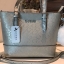 GUESS MINI CROSS BODY BAG กระเป๋าถือหรือสะพายรุ่นฮิตและขายดีที่สุดจาก GUESS FACTORY วัสดุหนังแก้วเงาสวยอยู่ทรง น้ำหนักเบา ด้านหน้าประดับด้วยโลโก้แบรนด์สุดหรูพร้อมปอมๆห้อยที่หูกระเป๋าถอดเเยกใช้ได้ เปิดปิดกระเป๋าด้วยซิปสะดวกใช้ ด้านในโล่งกว้างมีช่องซิปและช่