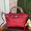 LONGCHAMP LE PLIAGE NÉO TOP HANDLE BAG XS คอลเลคชั่นสุดพิเศษจากลองฌอมป์ มีดีไซน์ที่เรียบหรูและคลาสสิก แฝงด้วยลูกเล่นแบบเฟมินีน แถมยังมีน้ำหนักเบาอย่างไม่น่าเชื่อ มาพร้อมกับหูจับกระเป๋าคู่และฝาปิดแบบกระดุม กระเป๋าถือใบนี้สามารถใช้ถือแบบทั่วไป มีสายสะพายถอด